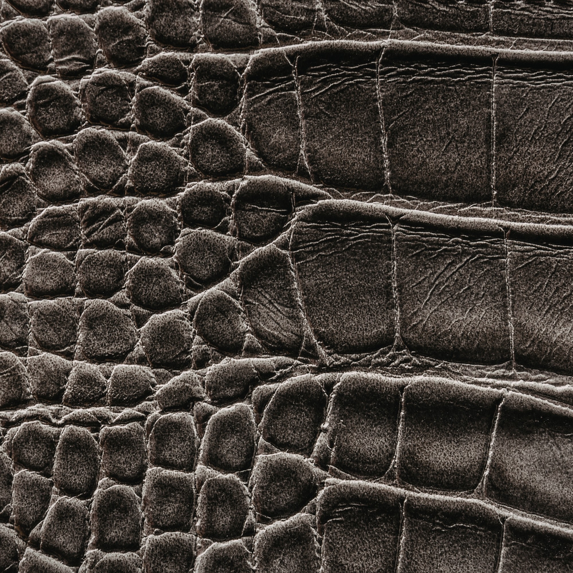 Aged leather background with a stitched border and brass studs