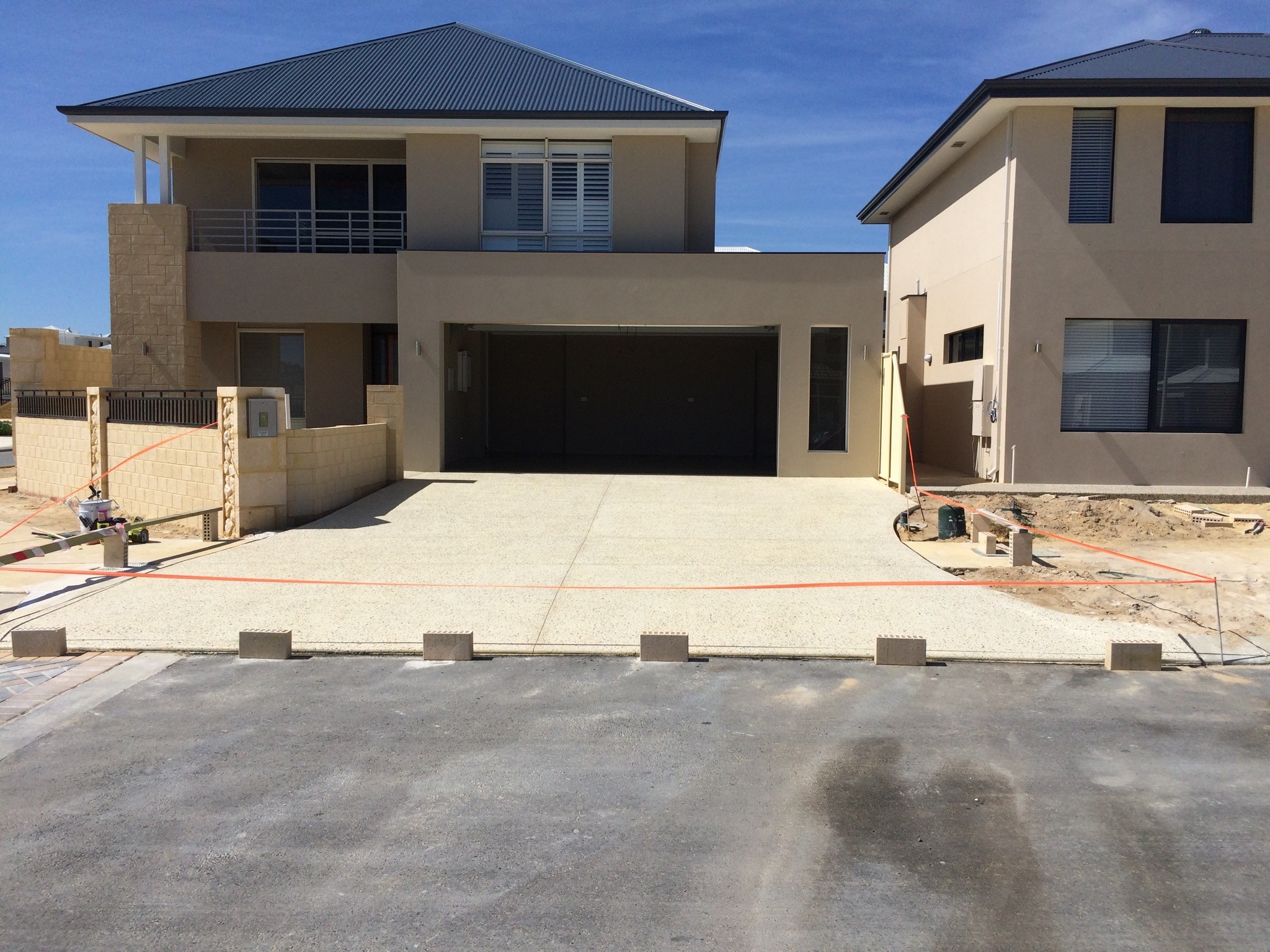 Hand rolls green yoga mat on light surface near plants.