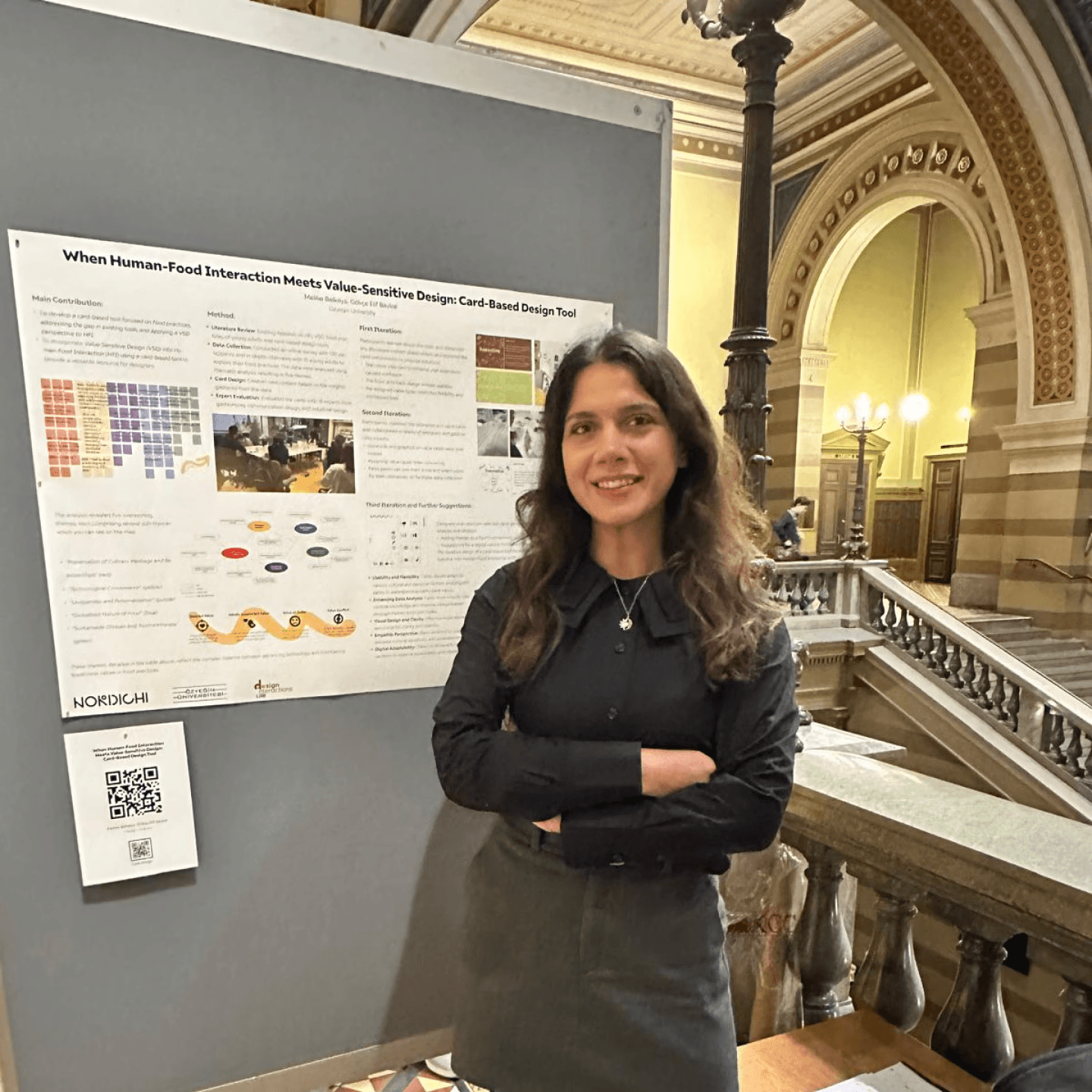 A woman presenting a poster about human food interaction at the NordiCHI conference.