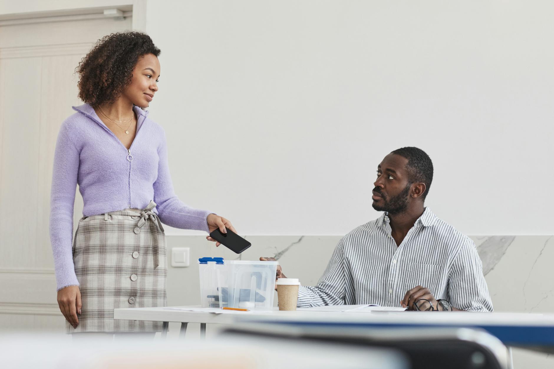 An educator stands at a whiteboard leading a peer group discussion on professional development for teachers.