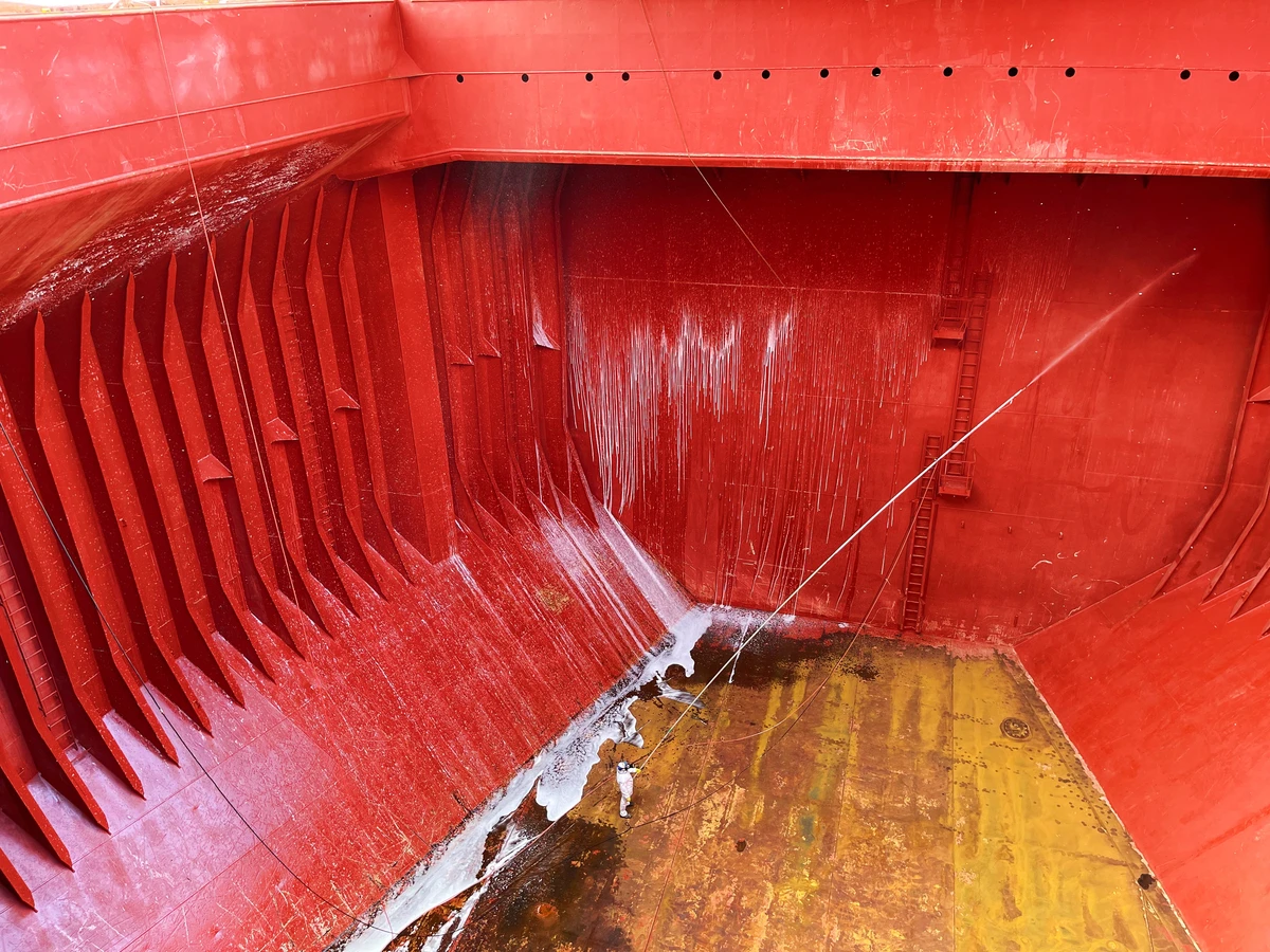 Seachios Marine Services cargo hold cleaning team carrying out high-pressure washing inside a bulk carrier in Brazil.