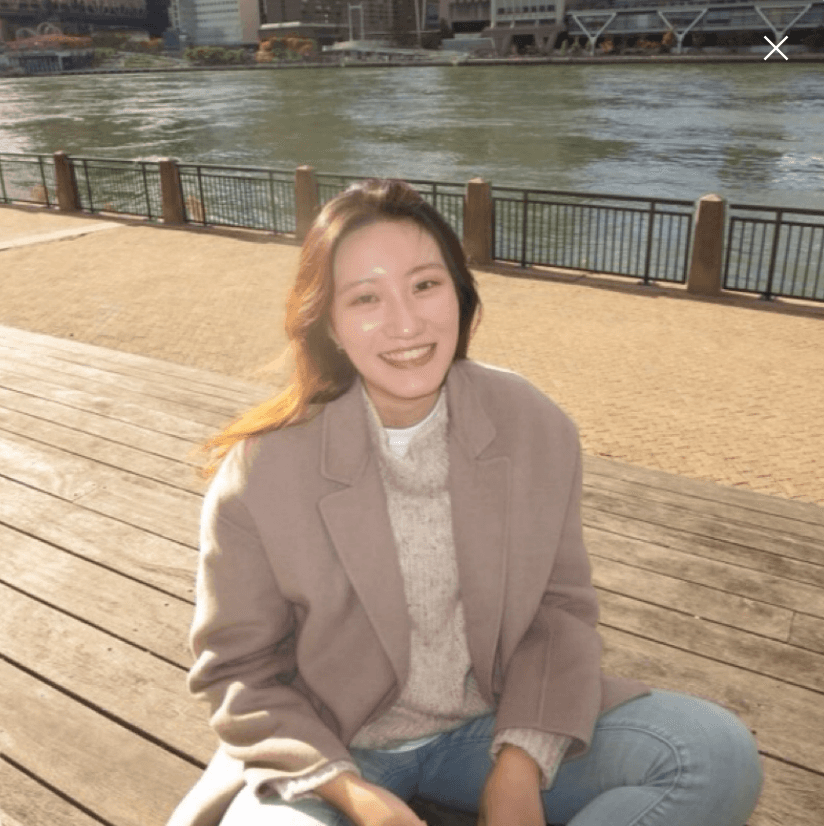 smiling woman wearing white and black pinstriped collared top
