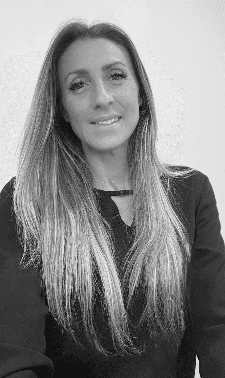 Frau mit langen Haaren lächelt vor dunklem Hintergrund.