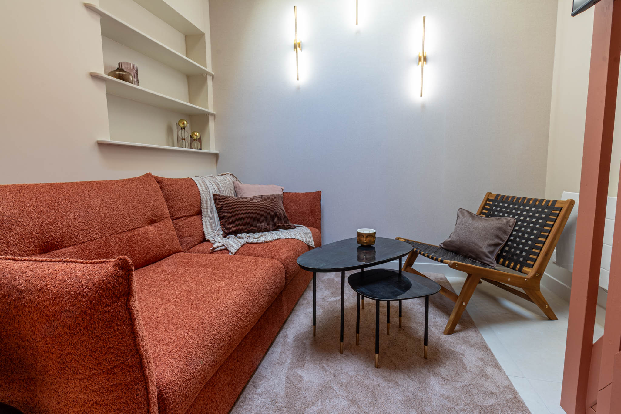 Modern bathroom with rustic cabinetry, sleek black countertop, and minimalist decor. Features a large mirror and natural lighting.