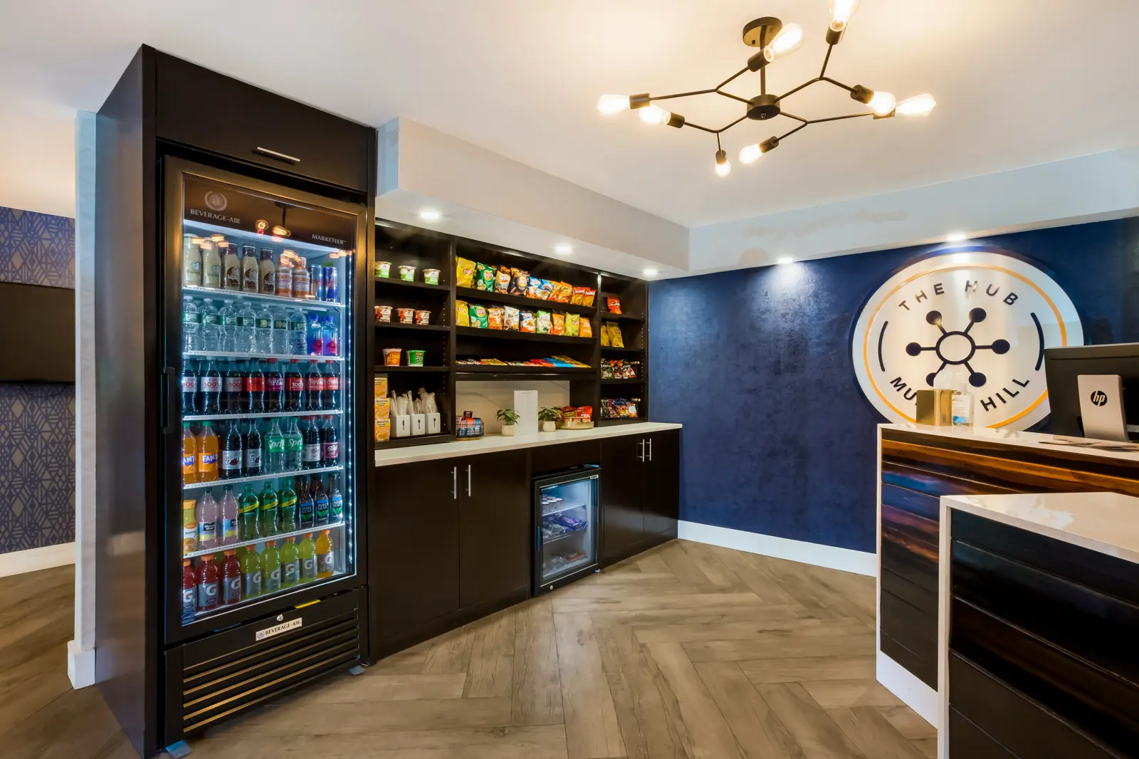Modern lobby with a front desk and a self-service snack & drink bar.