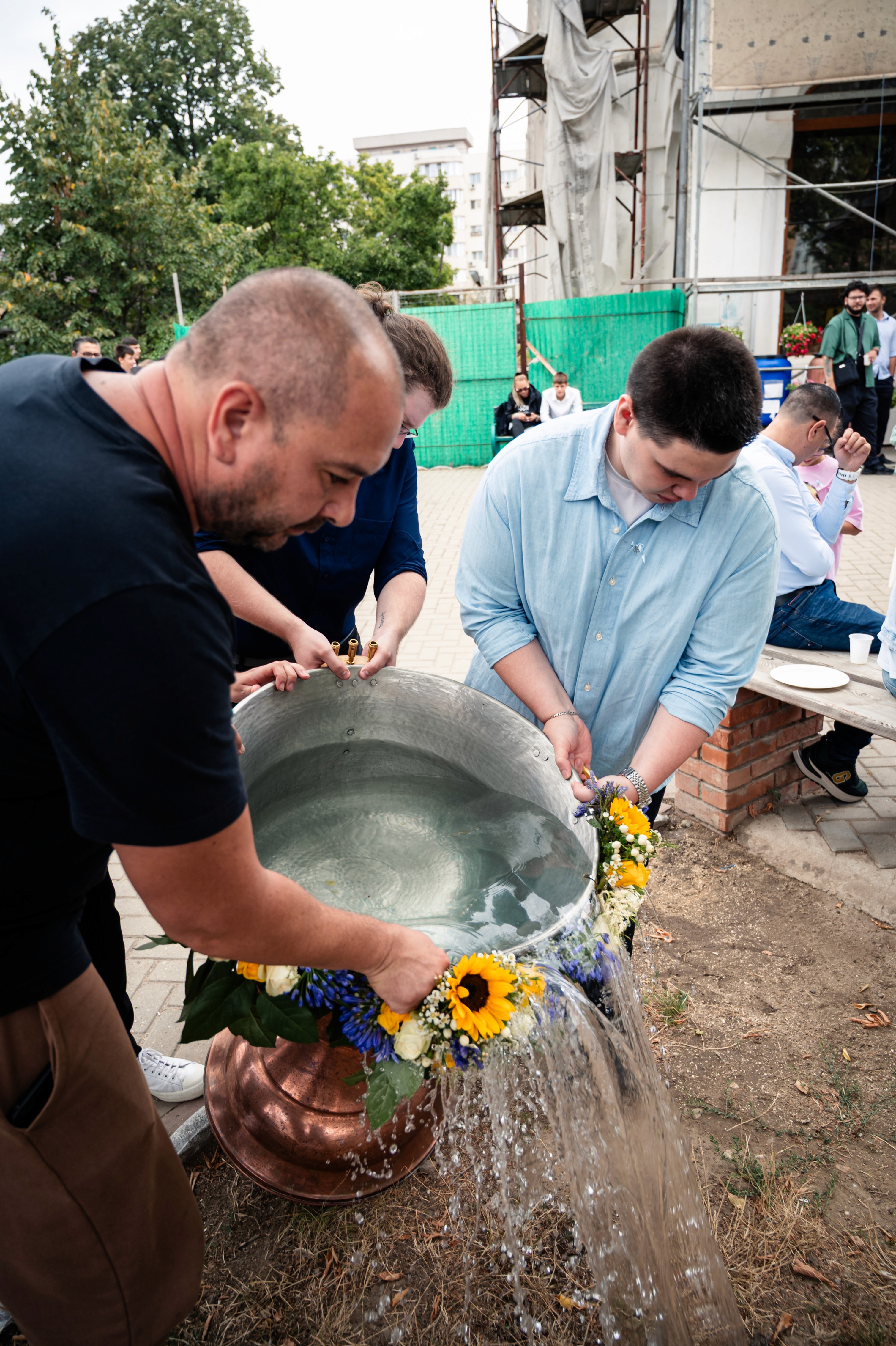 Tatăl și preotul pregătind cristelnița pentru botez — fotografie documentară de botez ortodox.