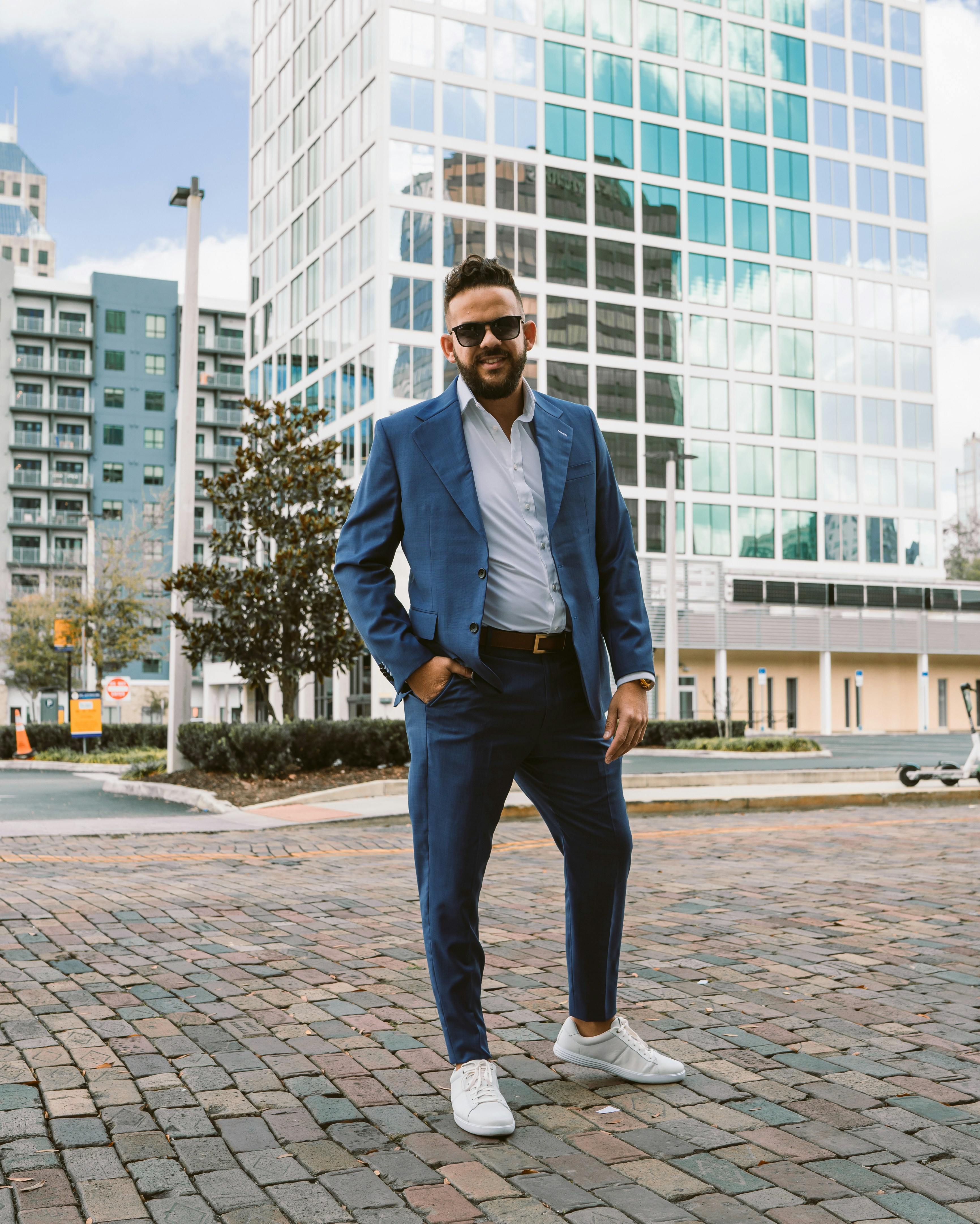 a man in a blue suit standing on a brick road