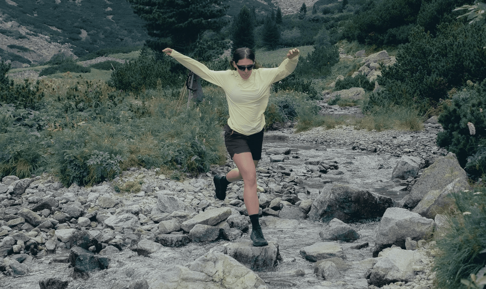 picture of a woman running next to the water stream.