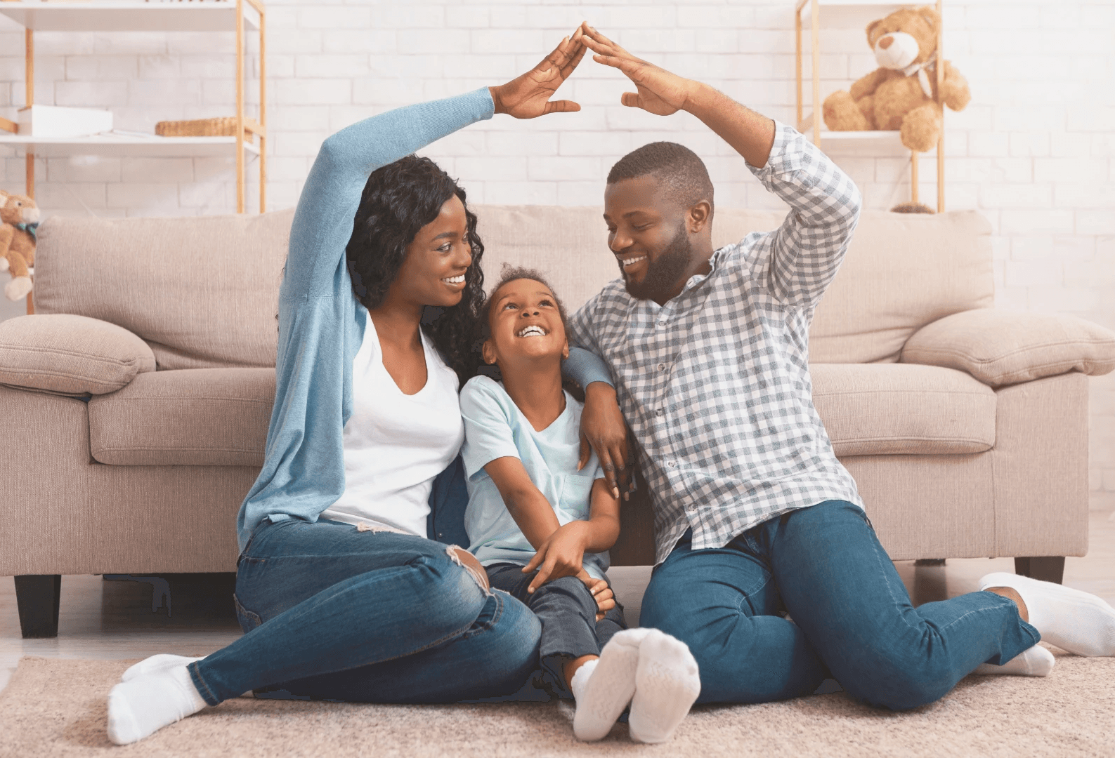 A happy family with a child sitting on a sofa, forming a heart shape with their hands. Cozy home environment.