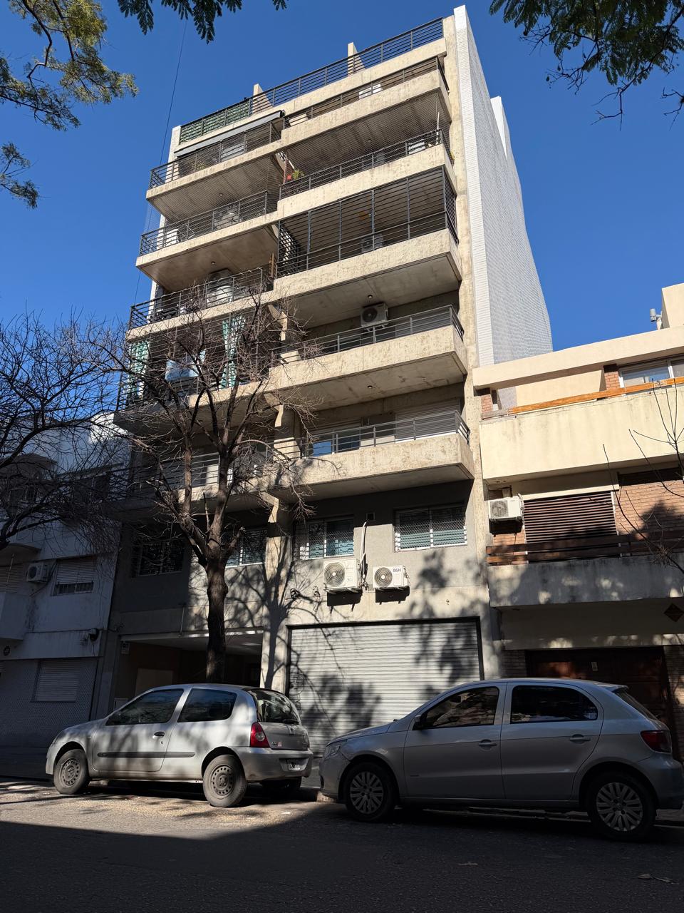 Frente de edificio de departamentos de varios pisos con balcones corridos y revestimiento de hormigón, Edificio Tesla, Rosario