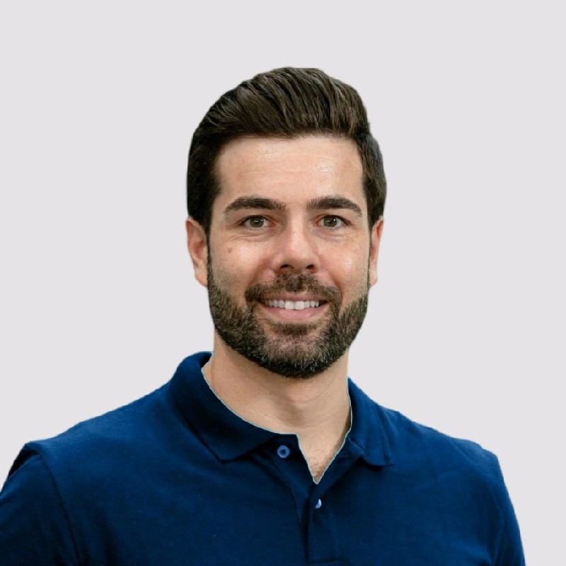 Uomo sorridente con barba in polo blu