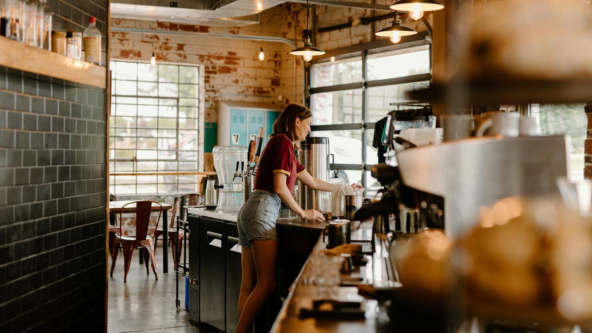 woman sitting while working on laptop and smiling