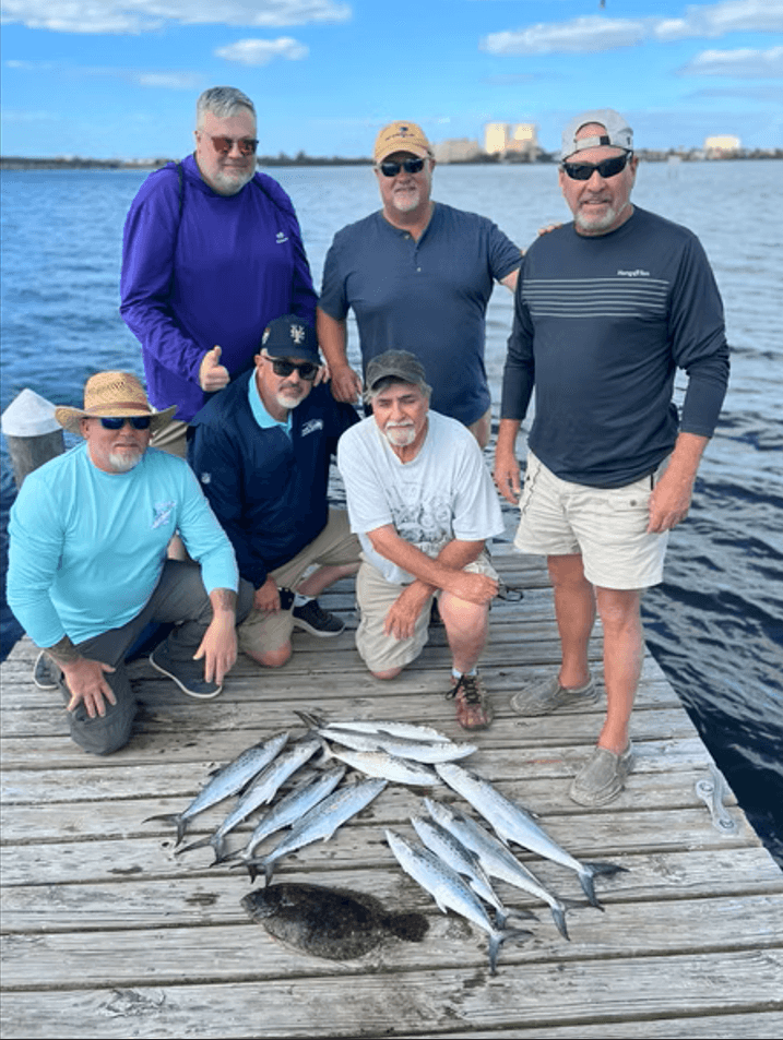 A party of six with a catch of Spanish mackerel and flounder at the dock