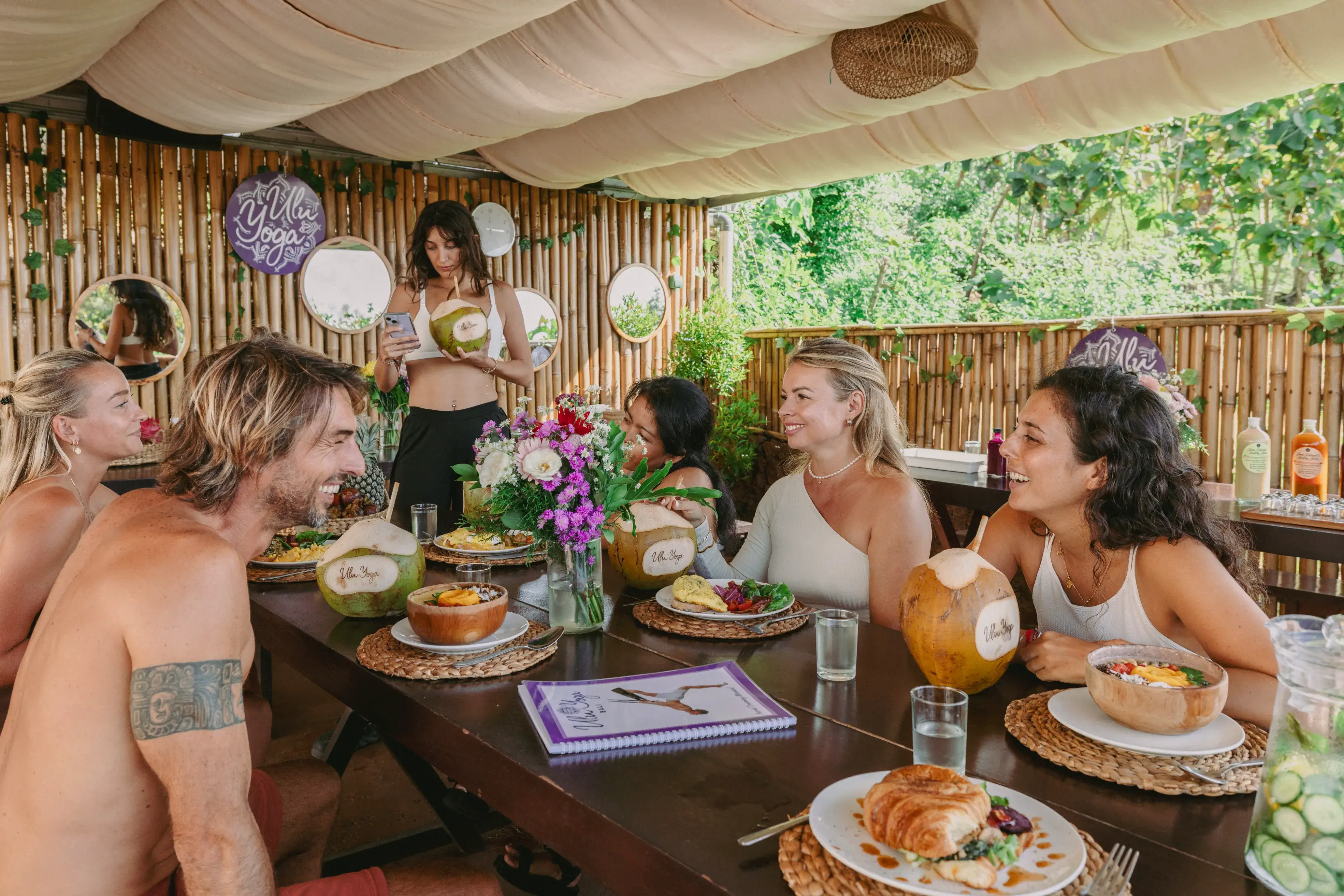 Students enjoying healthy meals and community bonding at the bamboo cafe during their 200-hour Bali yoga retreat