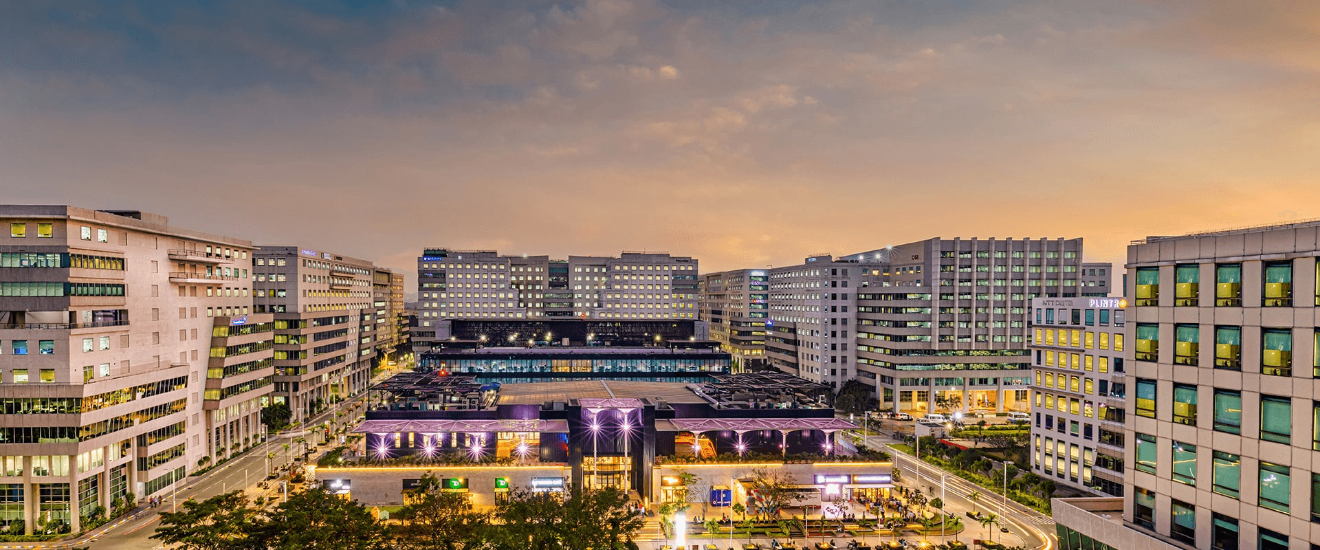 Modern cream-toned retail storefront with large floor-to-ceiling windows, symmetrical shelving displays, and a green rooftop garden under a clear blue sky.
