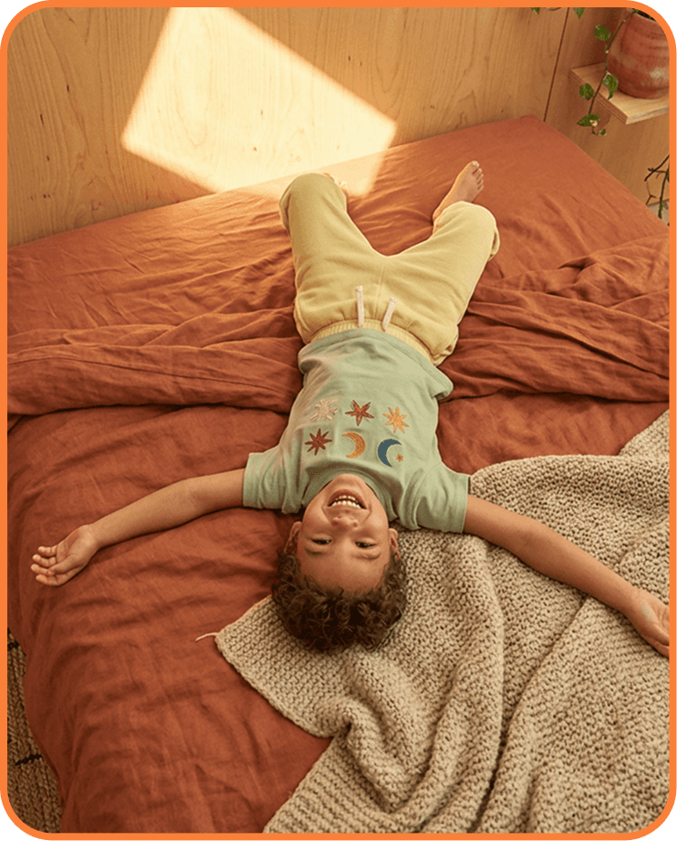 Child laughing on a bed
