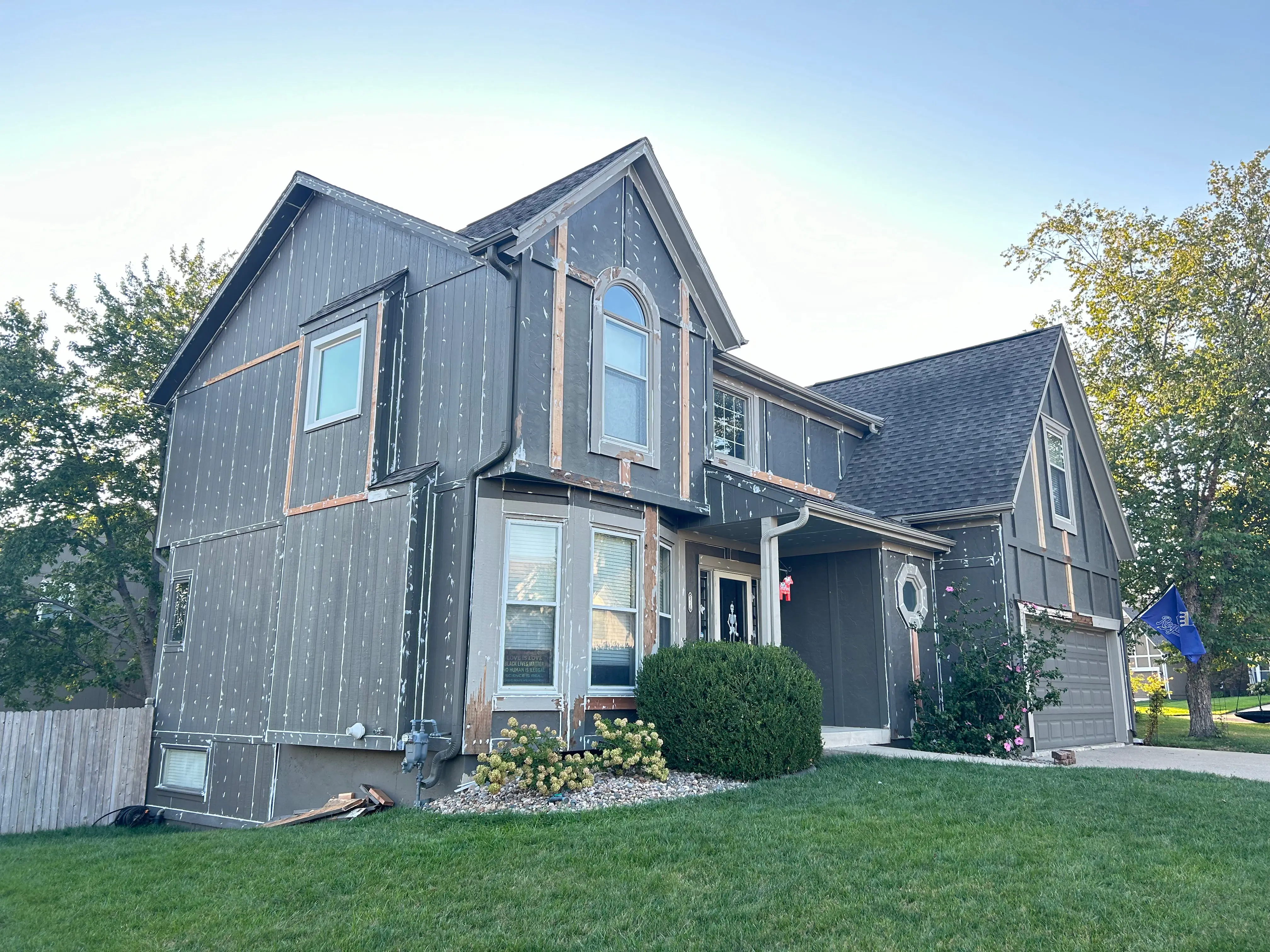 An image of a gey house being prepped for wood rot repair and painting.