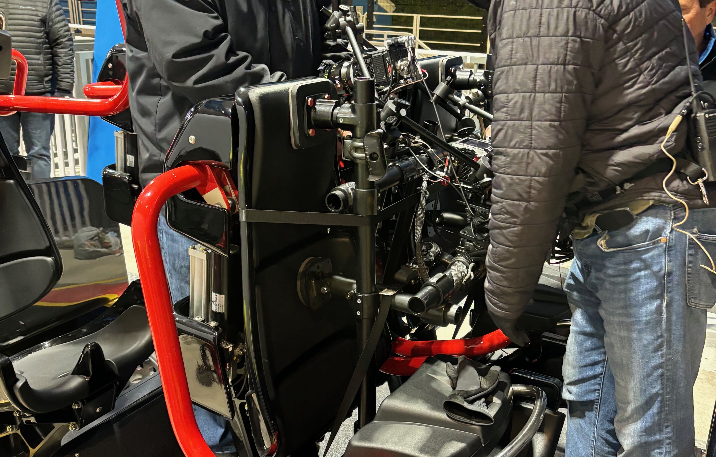 Two crew members inspecting a two-camera hard-mount rig on a new coaster in Ohio, with speedrail and ratchet straps visible securing the cameras