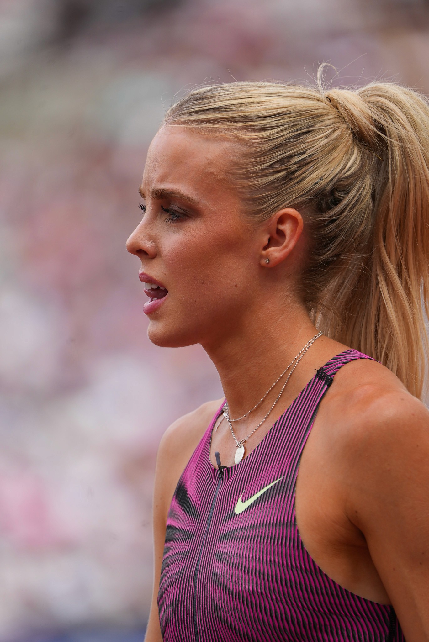 Close-up of a model holding wheat, dressed in a beige suit.