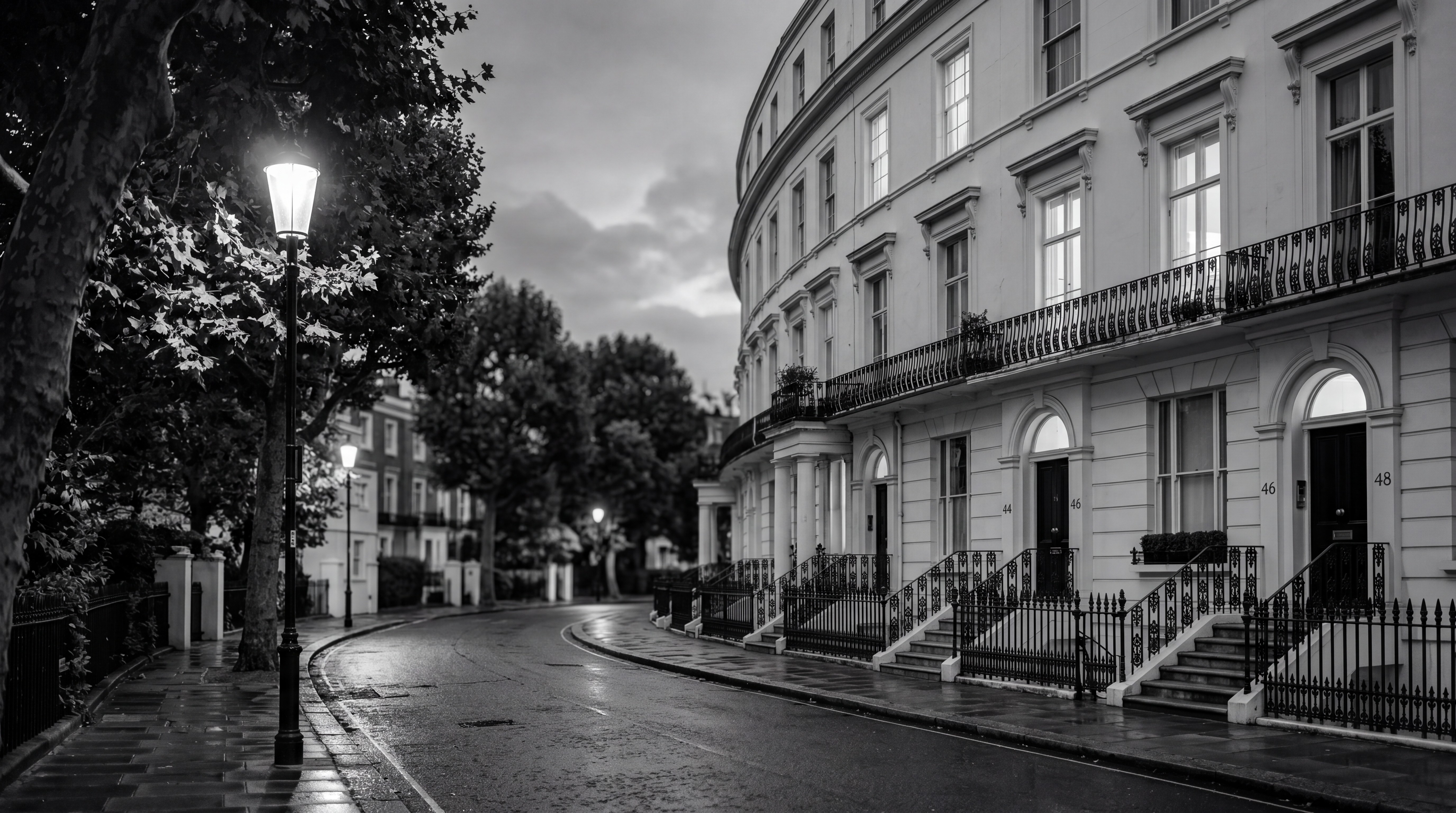Notting Hill stucco crescent at dusk with warm window light and mature plane trees, illustrating Prime London neighbourhoods absorbing AI wealth, monochrome editorial photograph