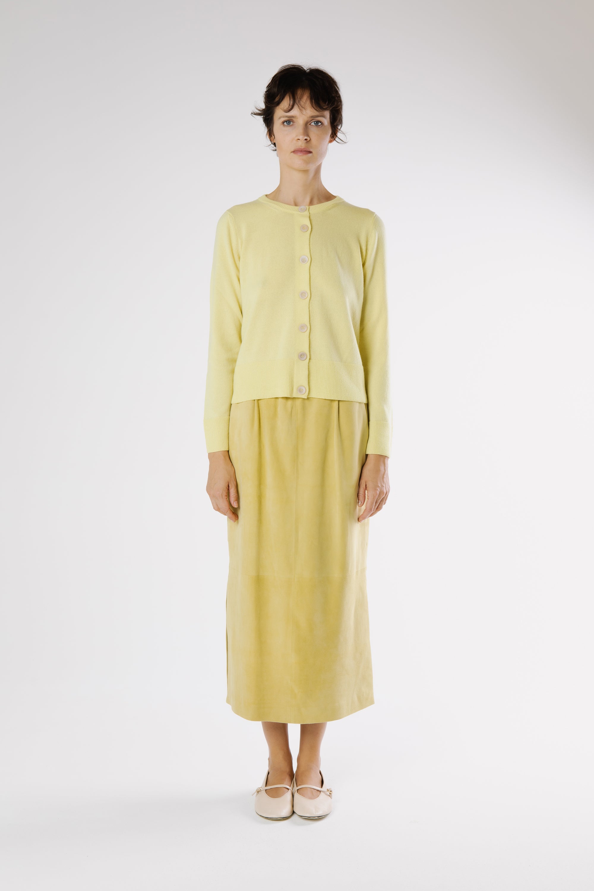 Model wearing Lemu yellow suede midi skirt with elastic waist, front view