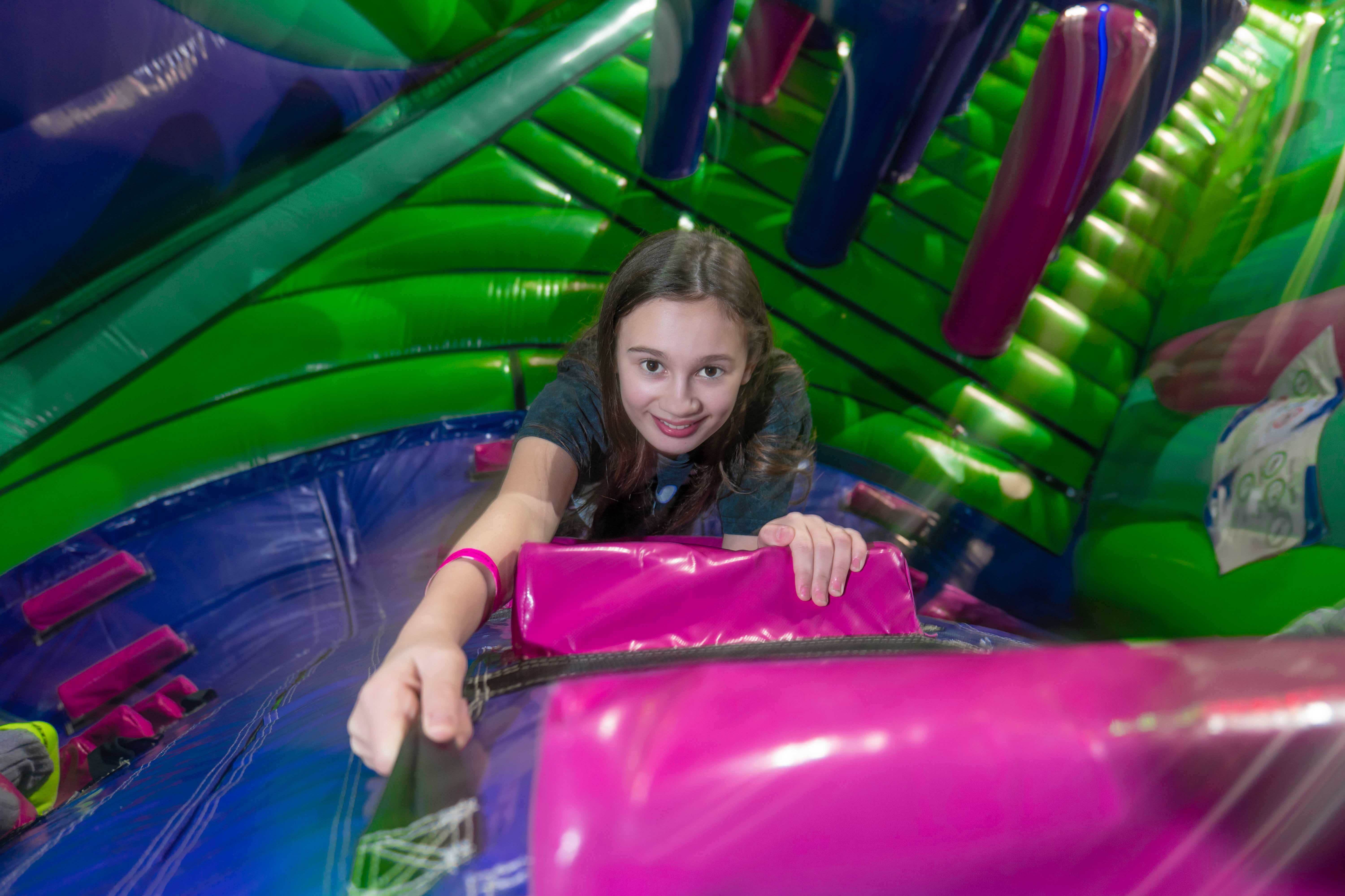 young girl hangin onto brigh coloured inflatables.