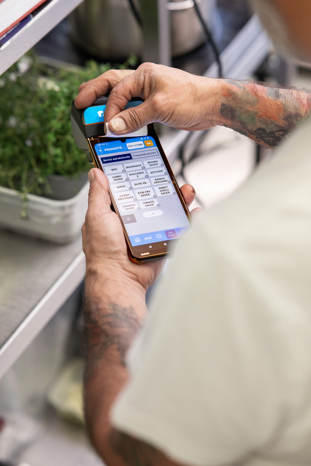A chef in a commercial kitchen using a Labl.it device to print out a food label.