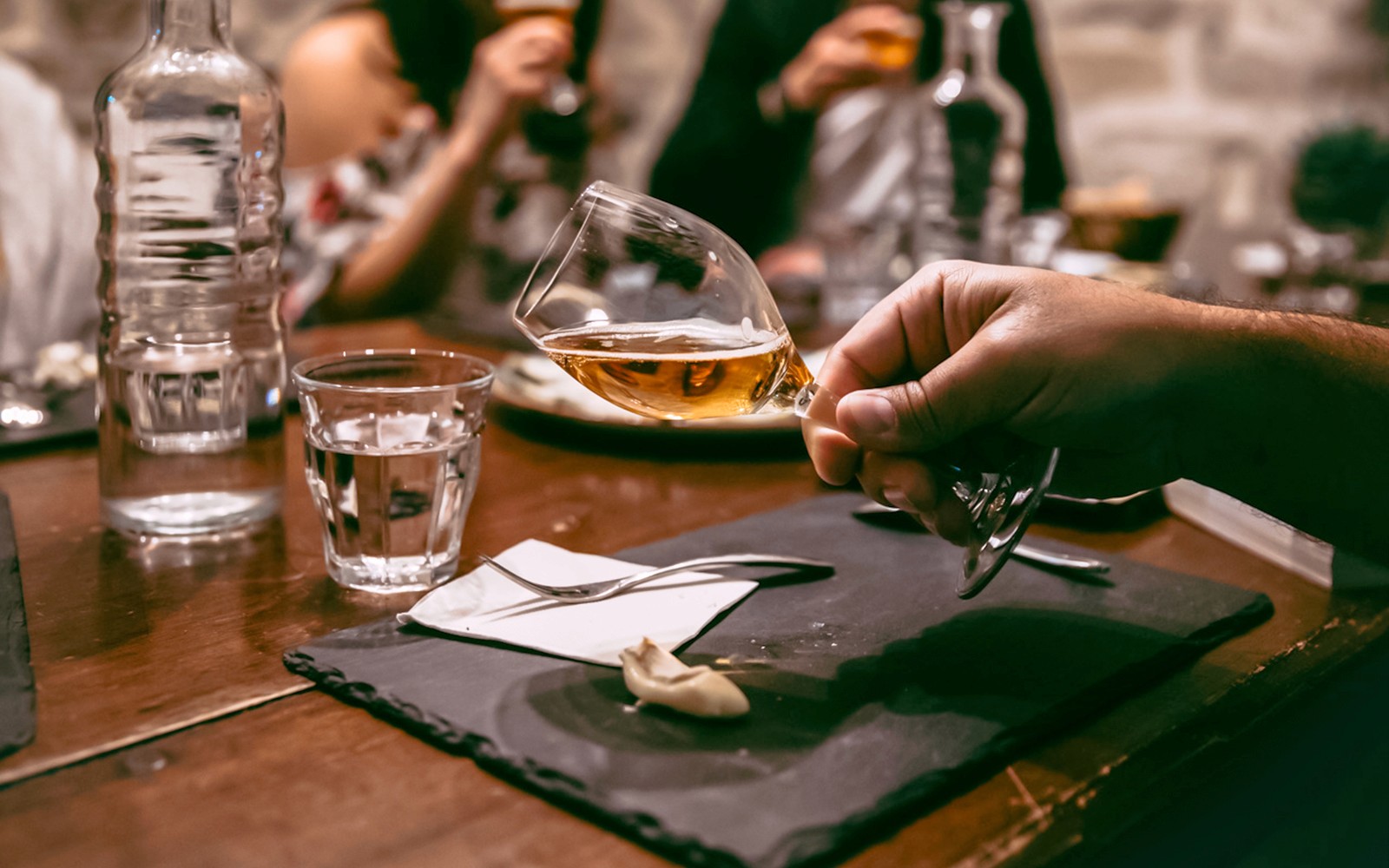 Paris, Fransa'daki Peynir Müzesi'nde masa üzerinde kadehler ve peynir eşliğinde şarap tadımı.