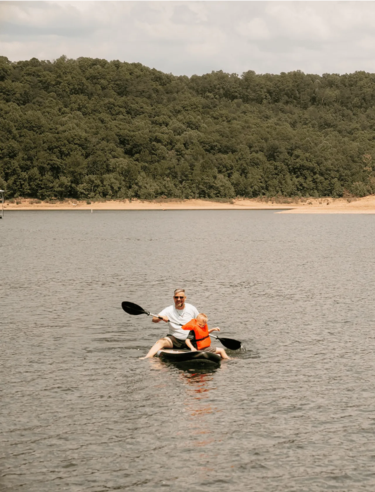 two people paddle boarding using a supplied paddle board included with the float home rentals