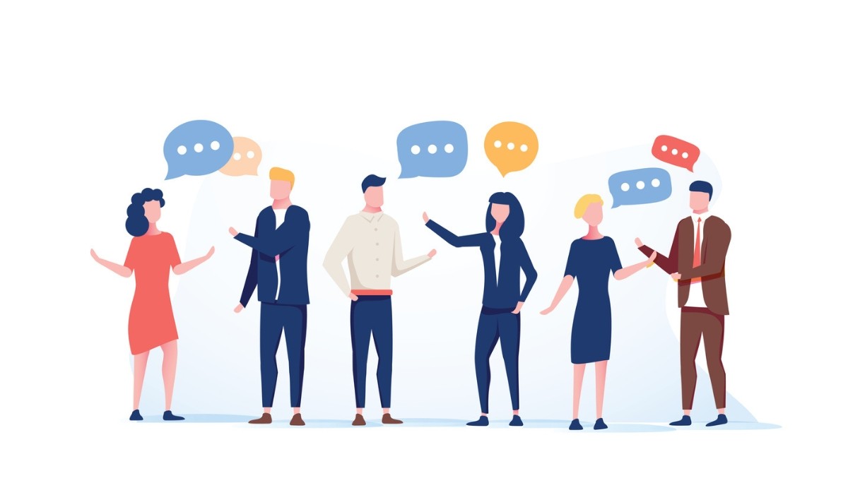 Illustration of six individuals engaged in lively conversation with colorful speech bubbles overhead, capturing the energy, diversity, and spontaneous dialogue that make in-person networking events valuable for building authentic professional connections.