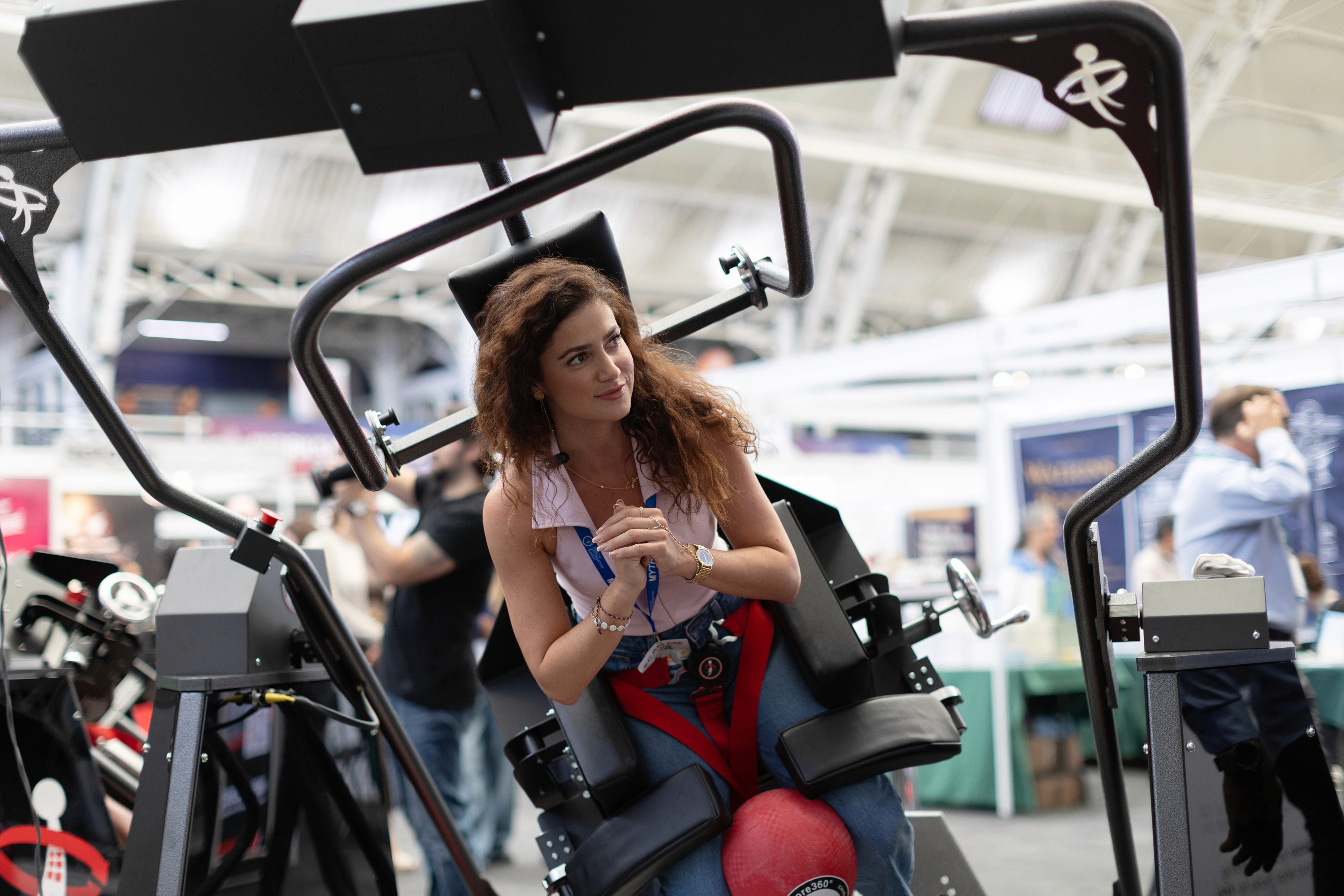Cozy reading nook with sofa, chair, and plants inside a glass cabin with mountain forest views.