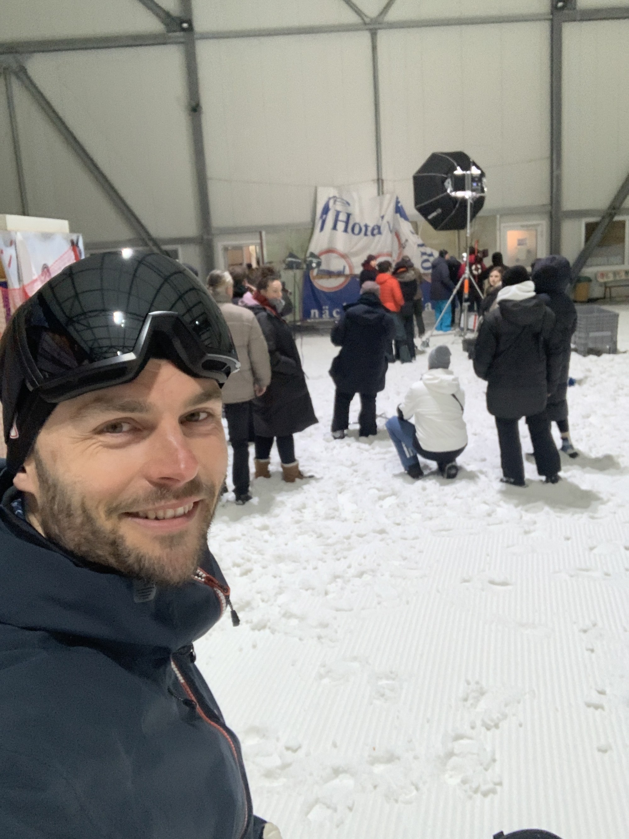 Selfie with helmet and ski goggles in front of the set in the ski hall — from behind the double is unrecognisable