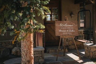 A wooden welcome sign for Clemmie and Tucker stands beside the cabin entrance.