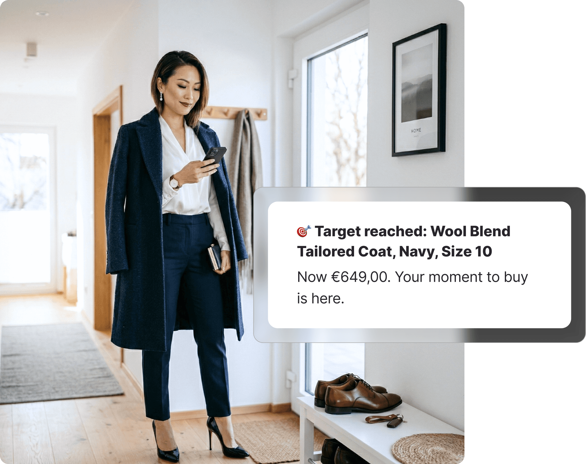 Smartly dressed woman in a navy wool coat checking her phone in a bright hallway, receiving a David Jones target price notification, with leather dress shoes on a bench beside her.