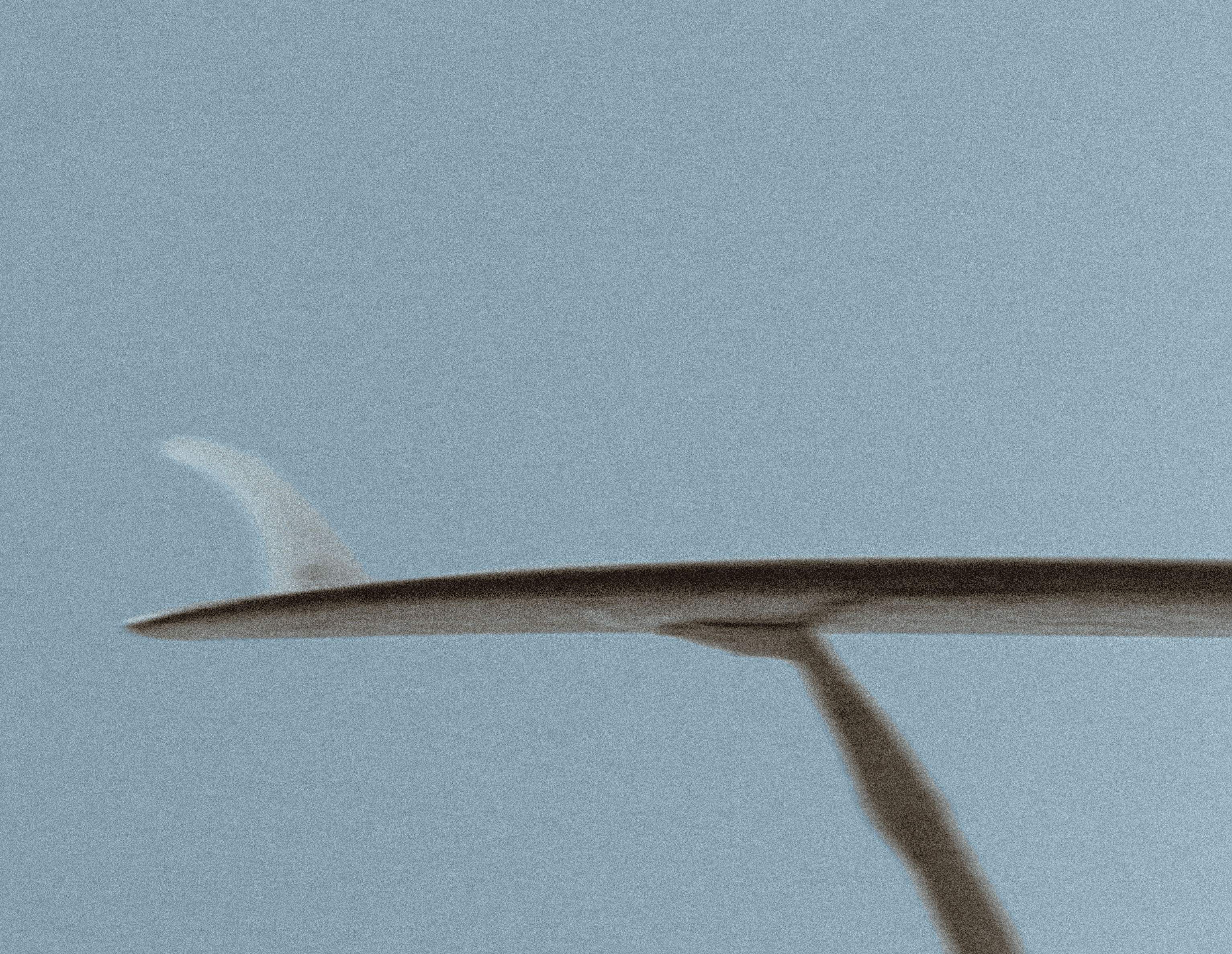 Hand holding surfboard at beach in ericeira portugal