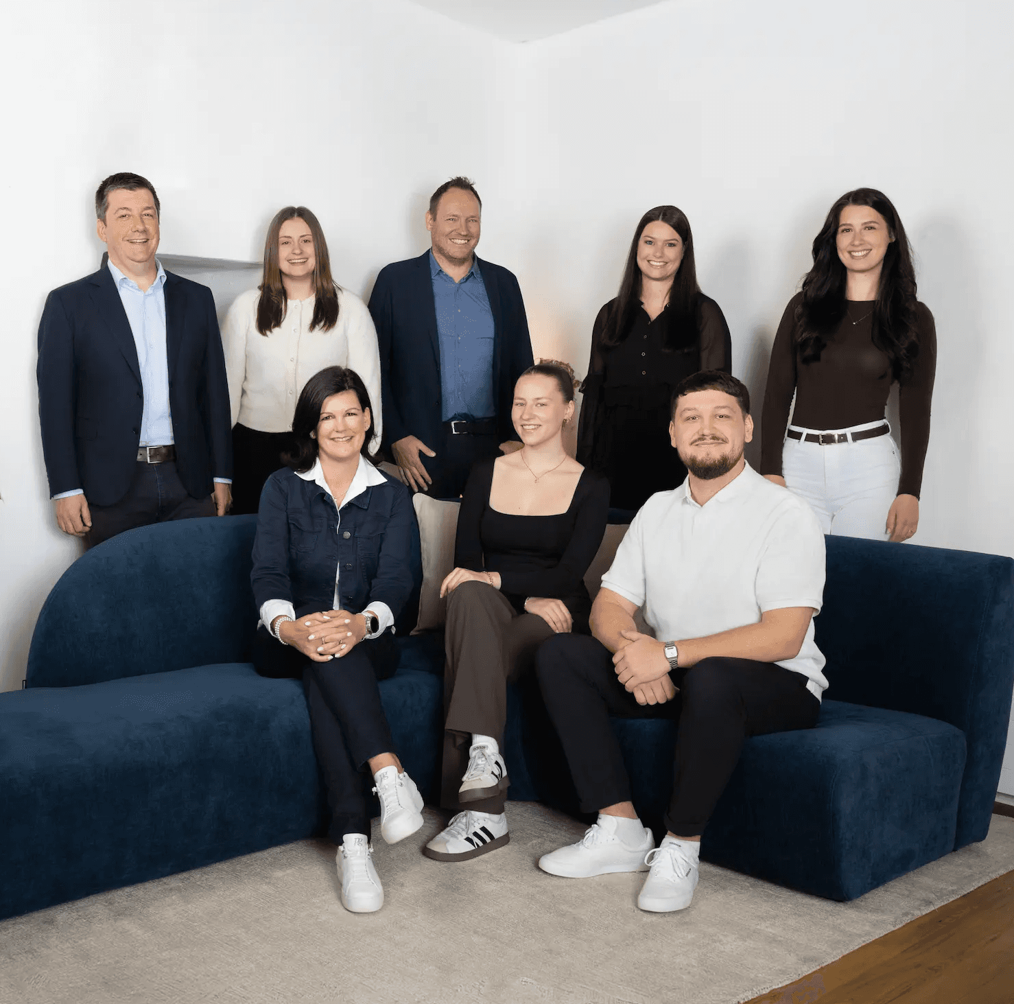 Gesamtes Kocher Immobilien Team sitzt auf einem Sofa in der ImmoLounge