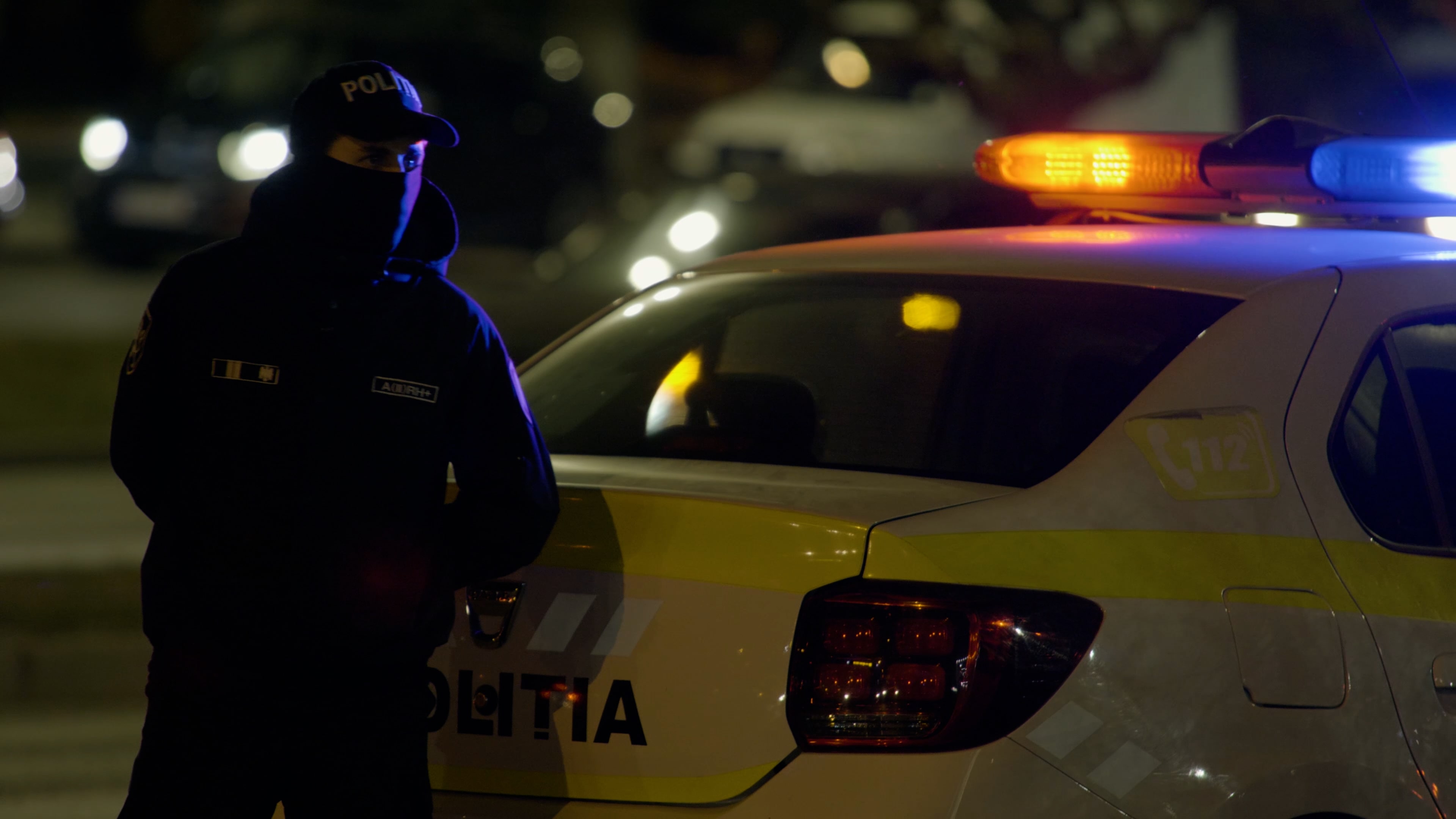 a policemen infont of a police car
