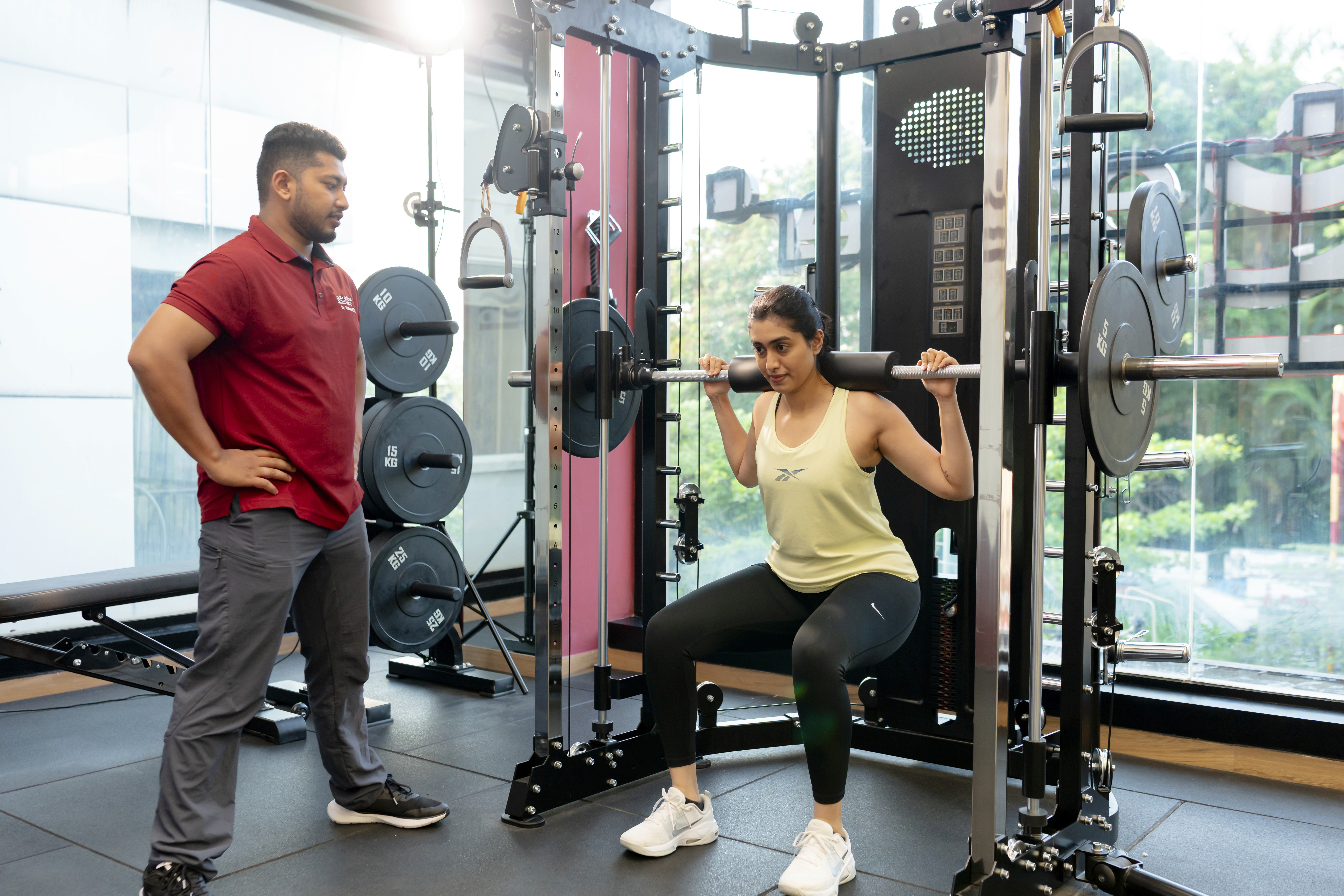 Trainer coaching a member through a supervised strength training session focused on safe and effective performance development.