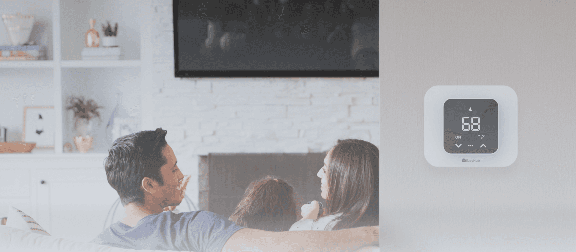 A family in the living room with a thermostat installed on the wall
