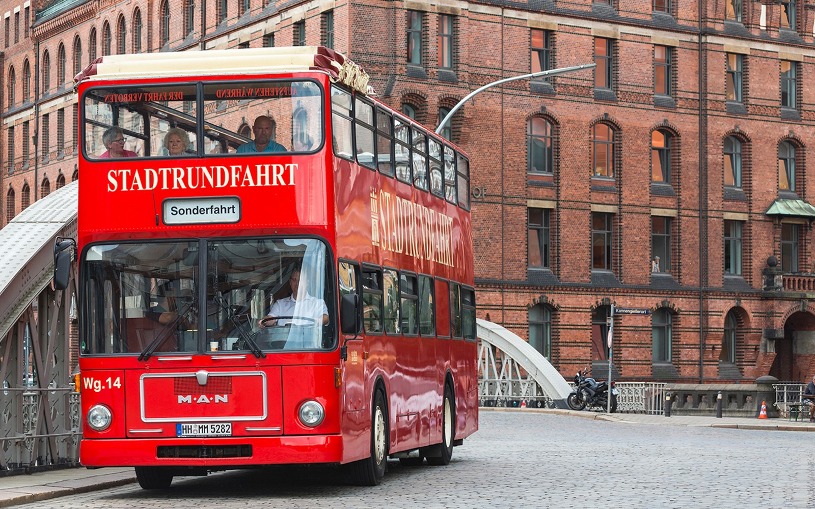 汉堡街道上的红色双层巴士,为您提供穿梭于历史悠久的砖瓦建筑附近的随上随下观光之旅。