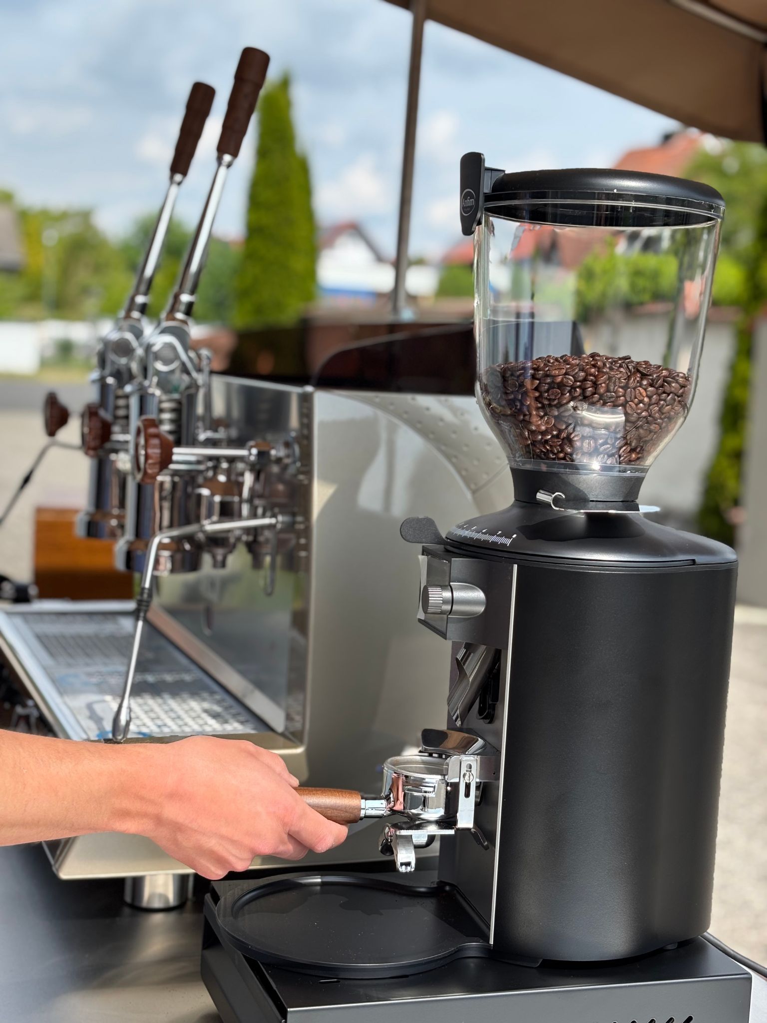 Hände bedienen eine professionelle Kaffeemühle – frischer Barista-Kaffee von 'Bens Beans' für eure Hochzeitsgäste.