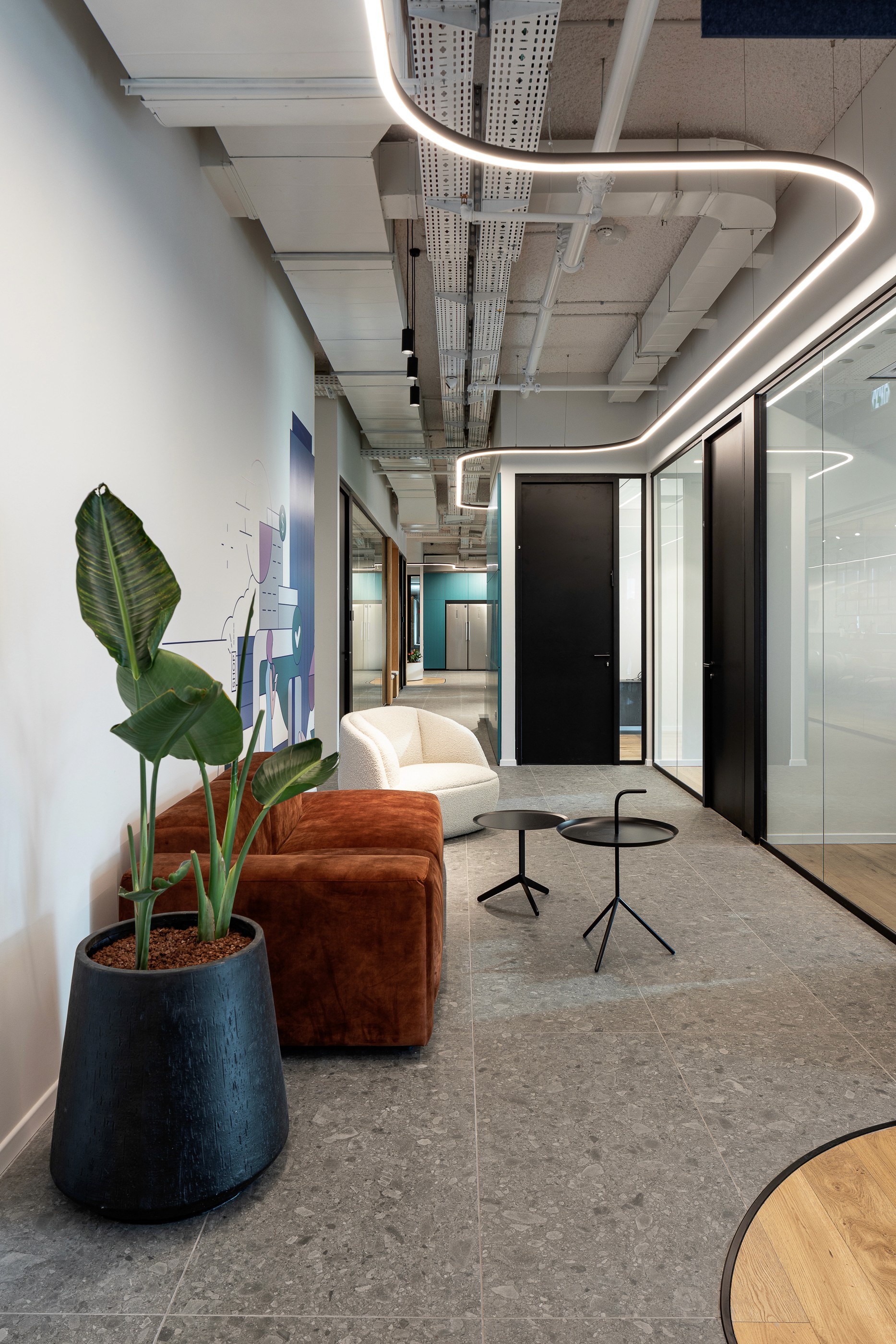 שקיפות ופרטיות: משרדים ושלוחות עבודה התחומים במחיצות זכוכית אקוסטיות, בשילוב צמחייה ירוקה (Biophilic Design) לאווירה נעימה.