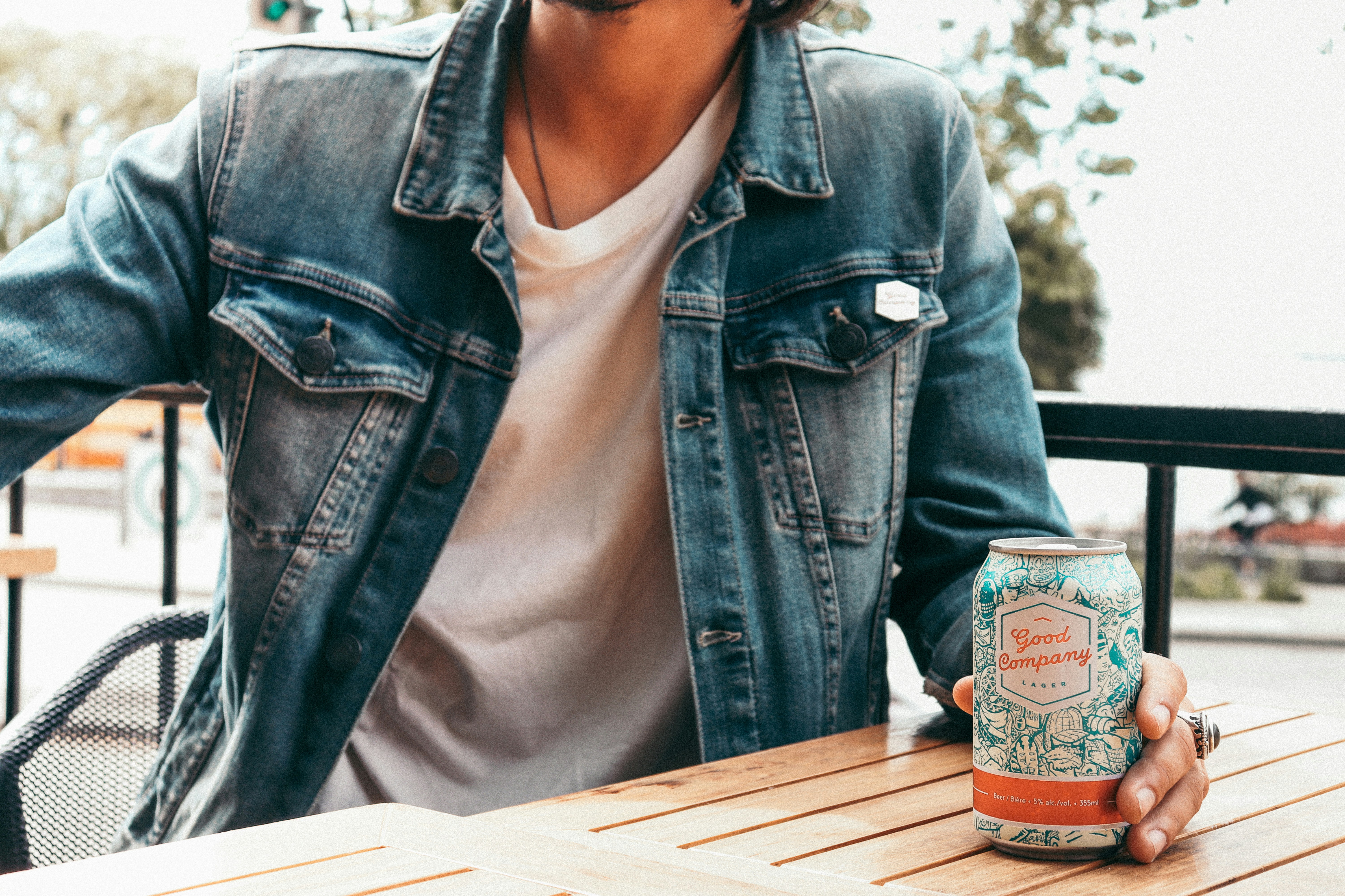 woman in blue denim jacket holding can