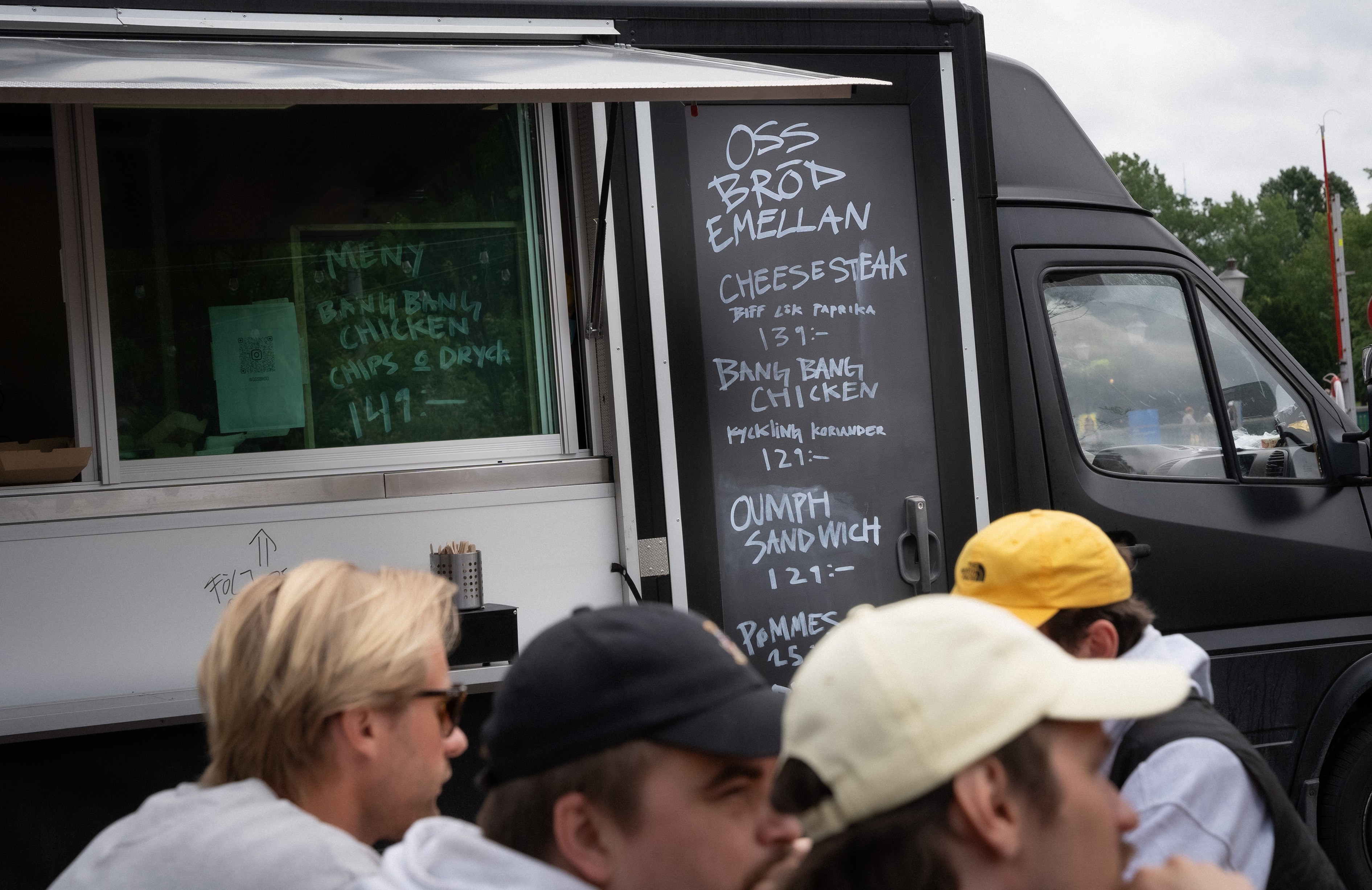Four friends in winter streetwear laughing in an underpass