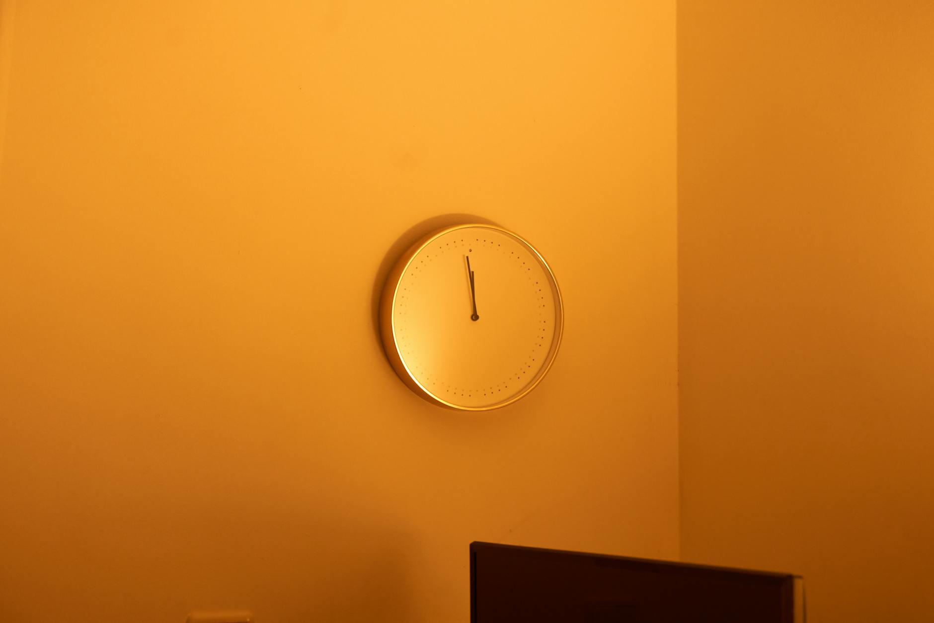 A wooden desk featuring a notebook, a pencil, and a classic alarm clock, perfect for teaching the time basics.