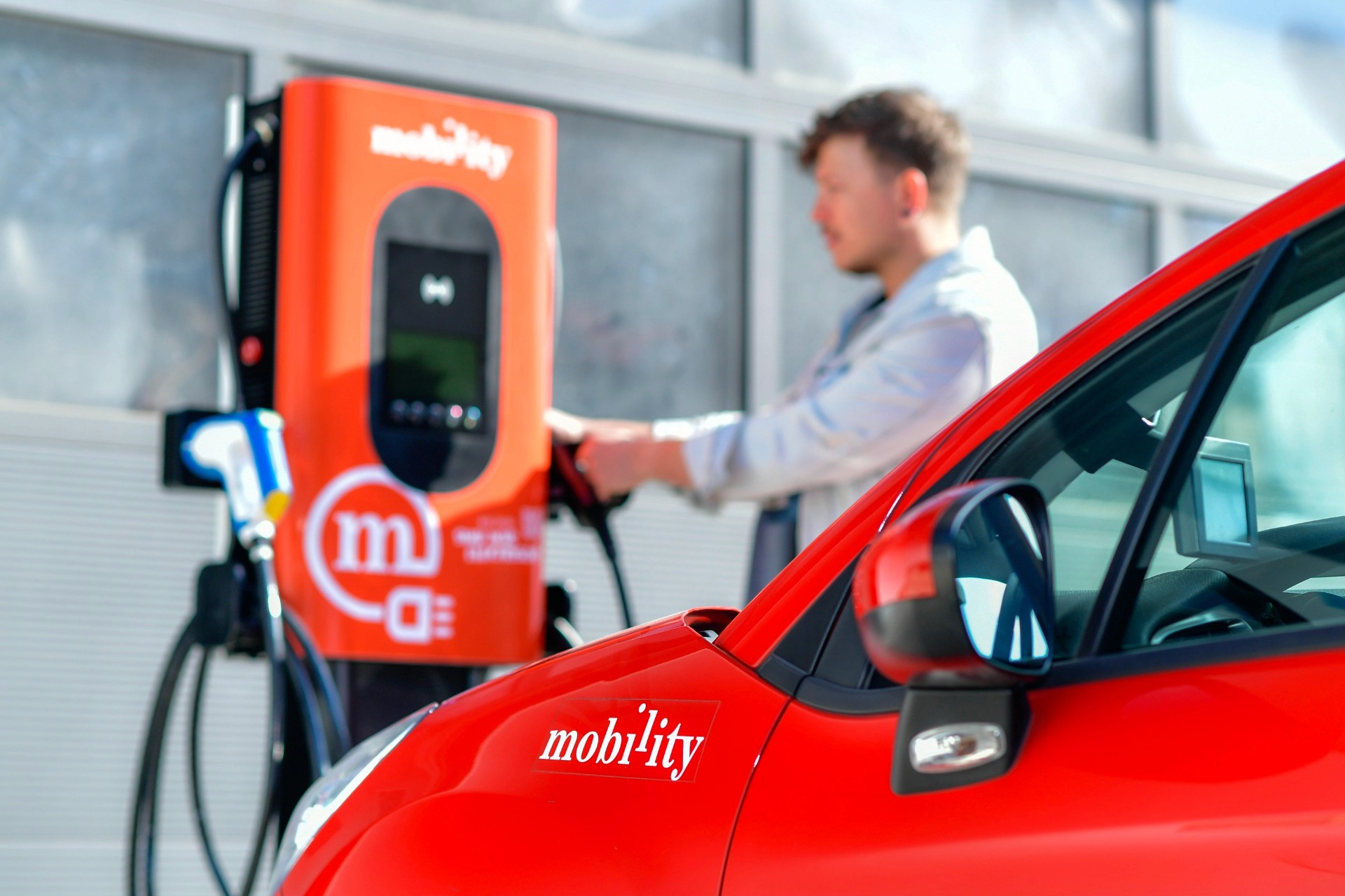 Mobility car sharing electric vehicle being charged at a charging station, representing the integration of electric mobility into car sharing services and promoting sustainable transportation in Switzerland