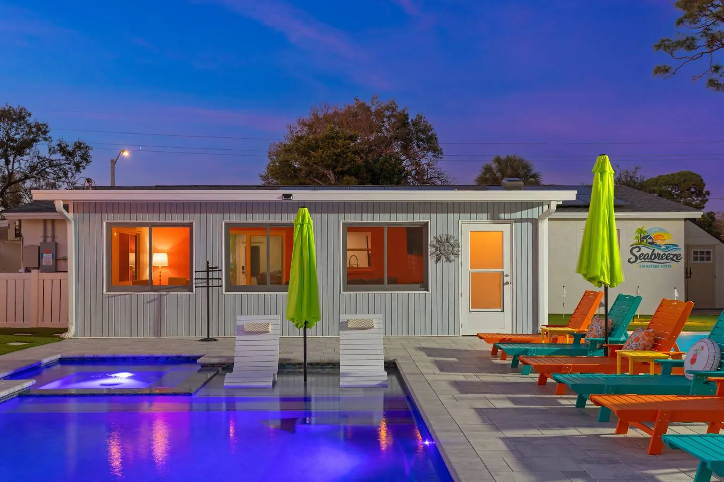Pool and hot tub lit at twilight with loungers at Pickleball Resort, Bradenton, Florida