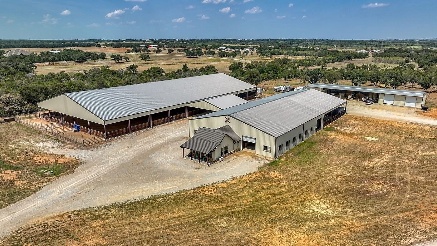 overhead drone view of large equestrian facility two large warehouse sized buildings for horses