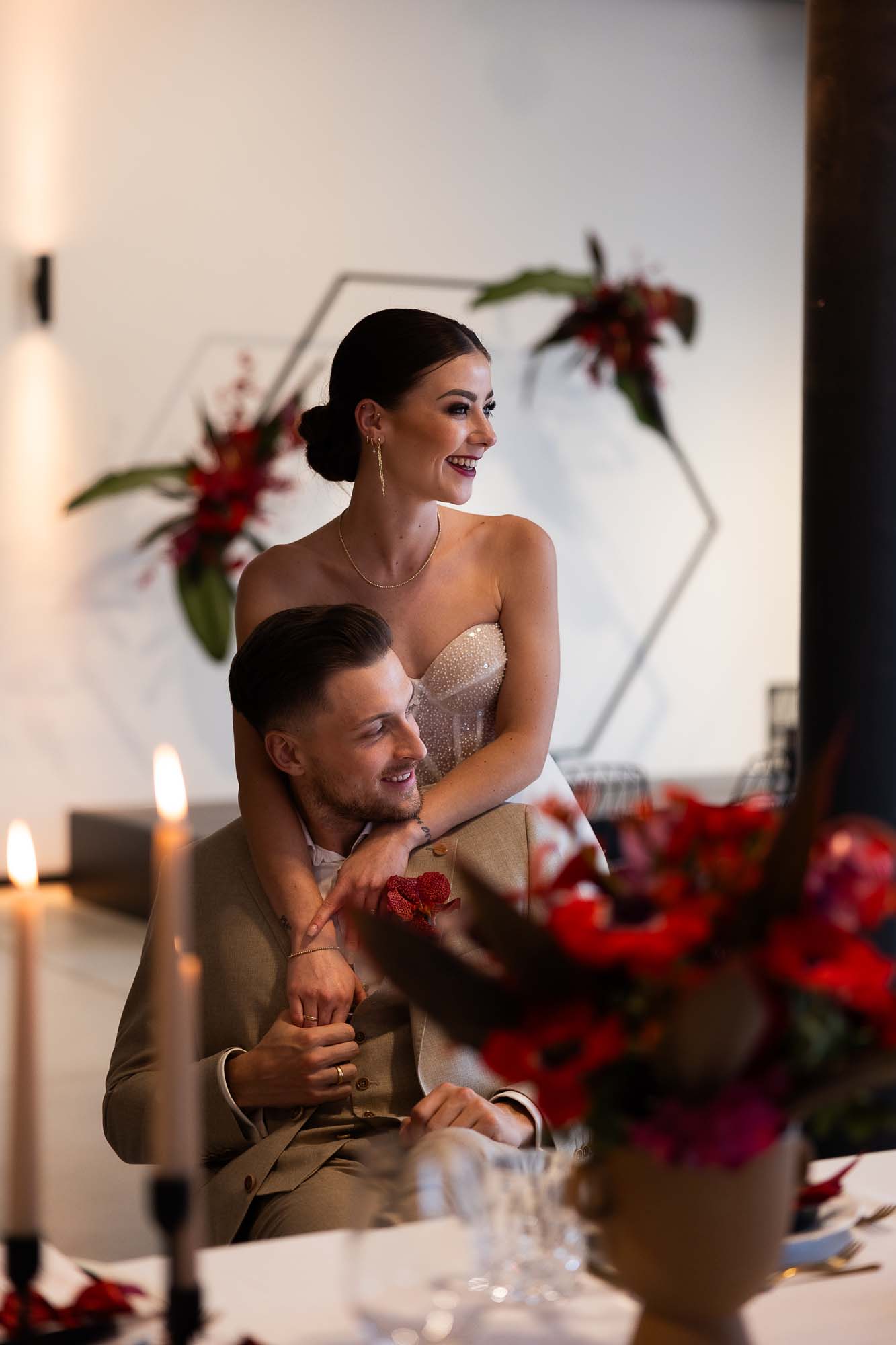 Braut steht hinter ihrem Ehemann und beide lachen.