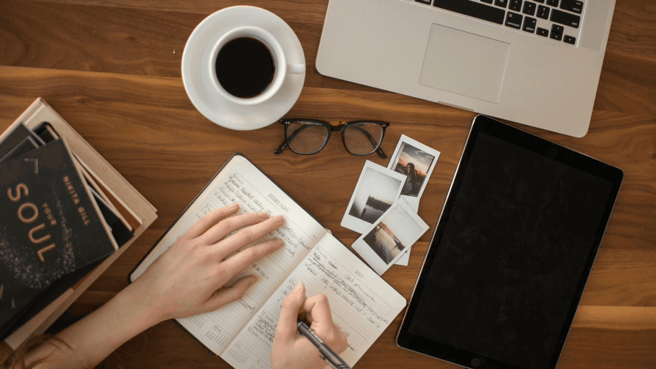 Person writes in planner beside coffee -  Emotional Hooks